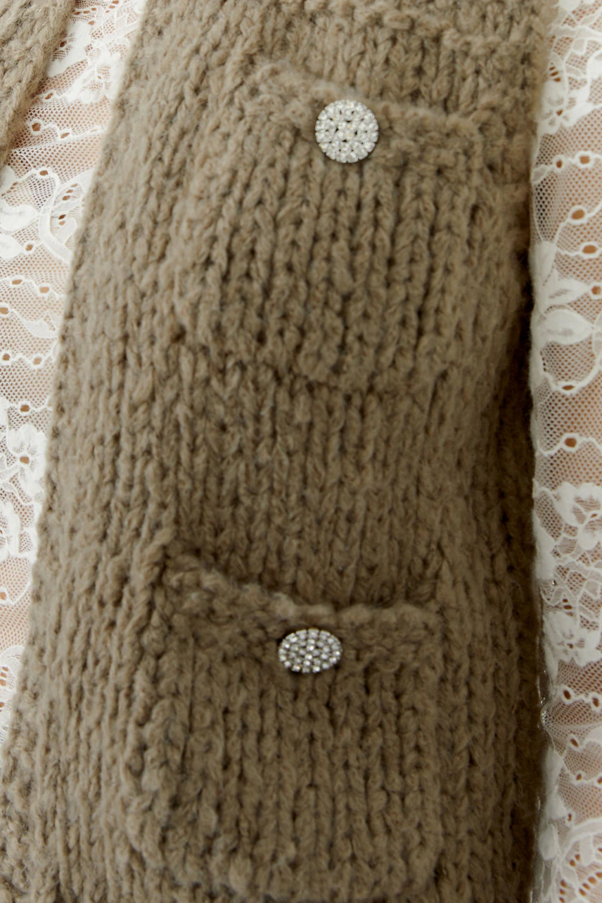 Beige Strickweste mit zwei Taschen und glitzernden Knöpfen, ideal für lässige Outfits.