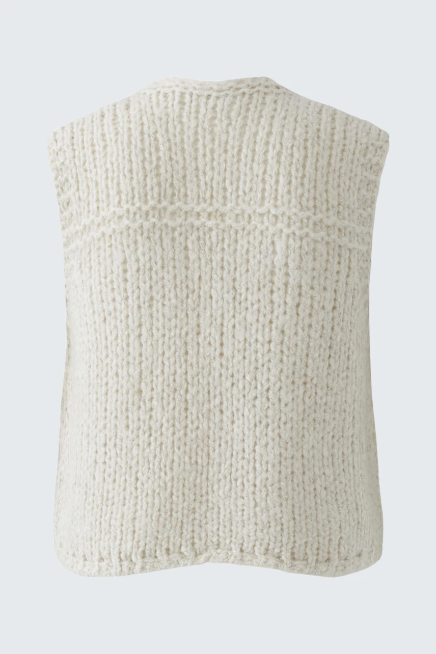 Casual women's knit vest in soft cream color, featuring a relaxed fit and textured design.