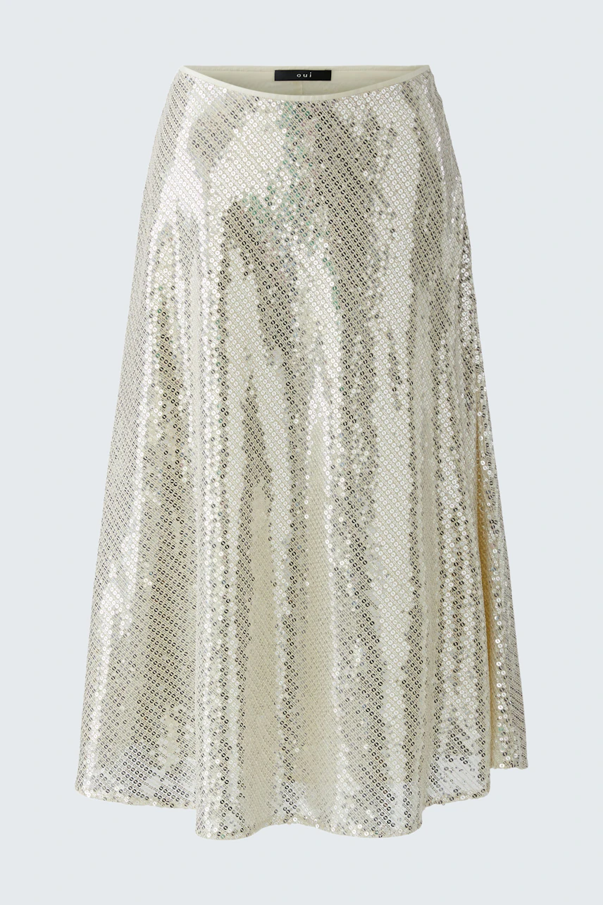 A-line skirt: A woman in a shimmering, knee-length skirt with sequins, showcasing a playful style.