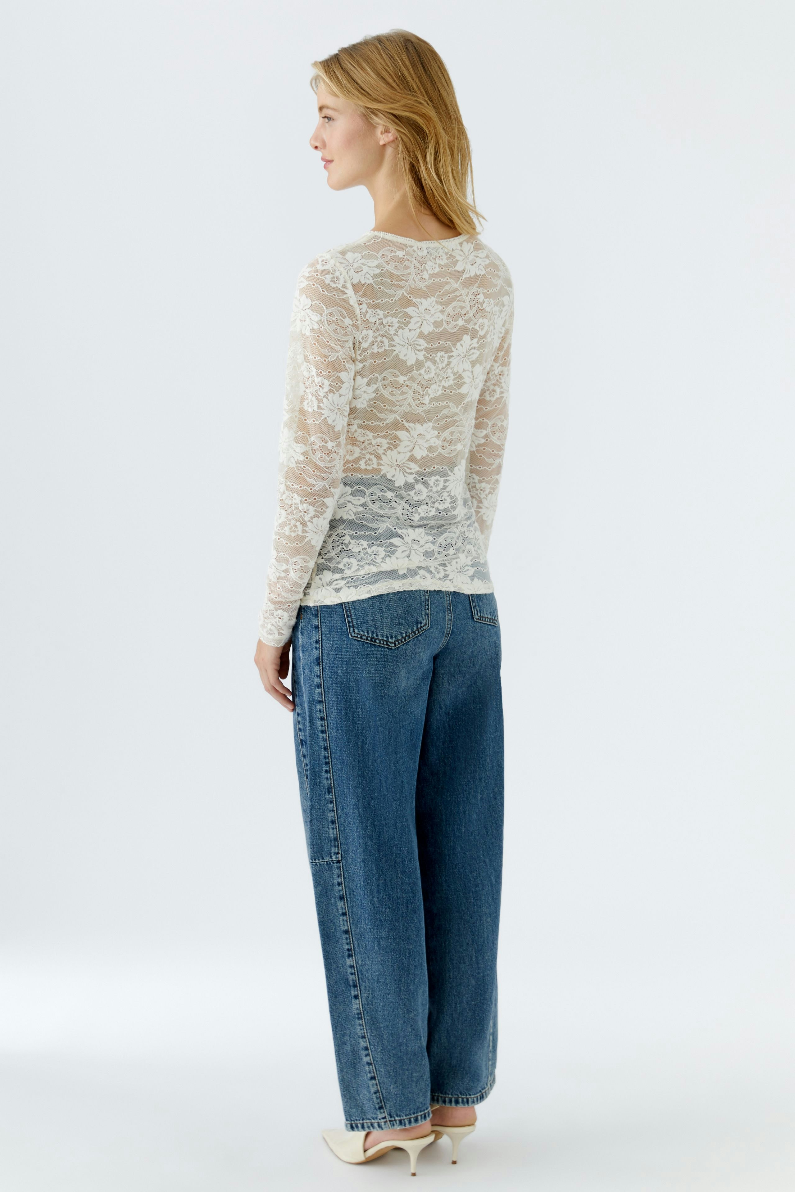 Lightweight long-sleeve shirt: Woman in a sheer lace top paired with relaxed-fit jeans.