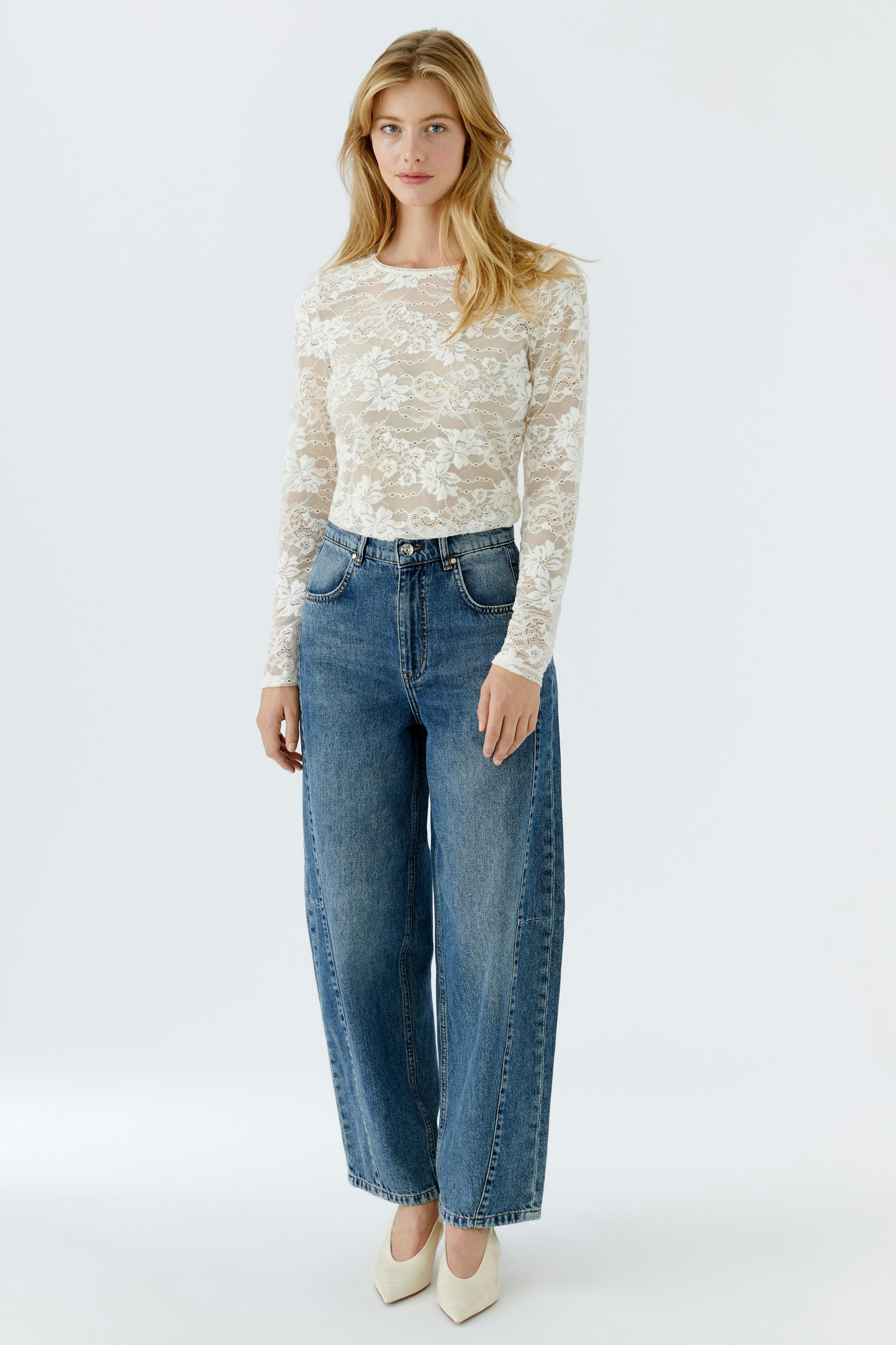 Long-sleeve shirt: Woman in a white lace top paired with wide-leg jeans, exuding a casual vibe.