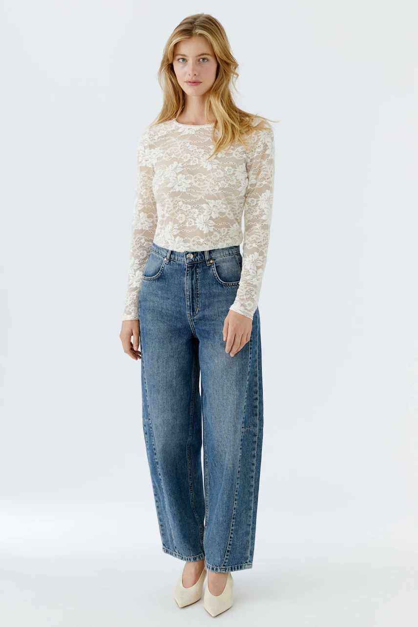 Long-sleeve shirt: Woman in a white lace top paired with wide-leg jeans, exuding a casual vibe.