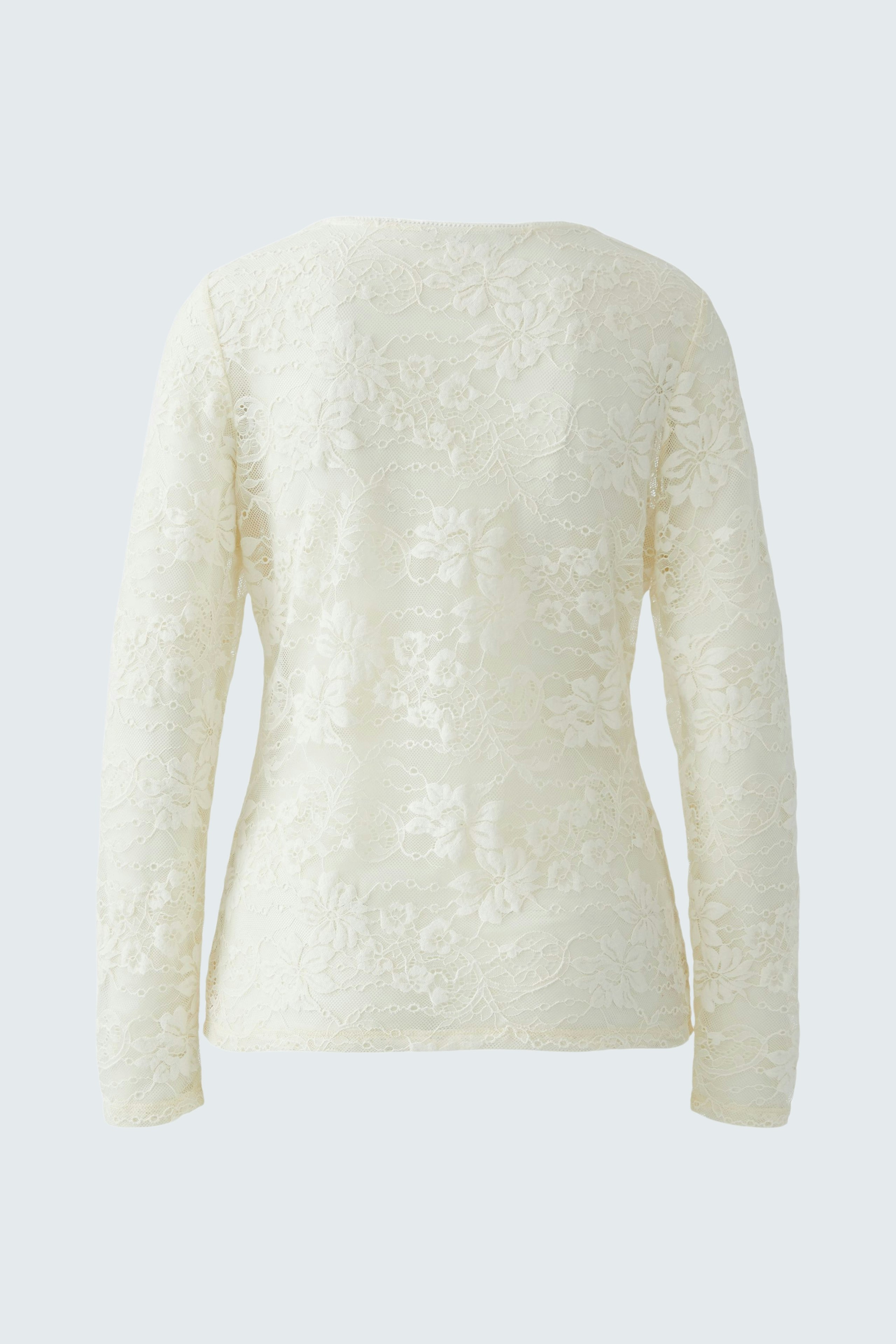 Casual long-sleeve shirt: A woman in a white floral-patterned pullover, showcasing a relaxed style.