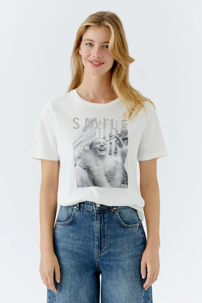 Casual women's T-shirt: Young woman in a white tee with a graphic print and relaxed fit.