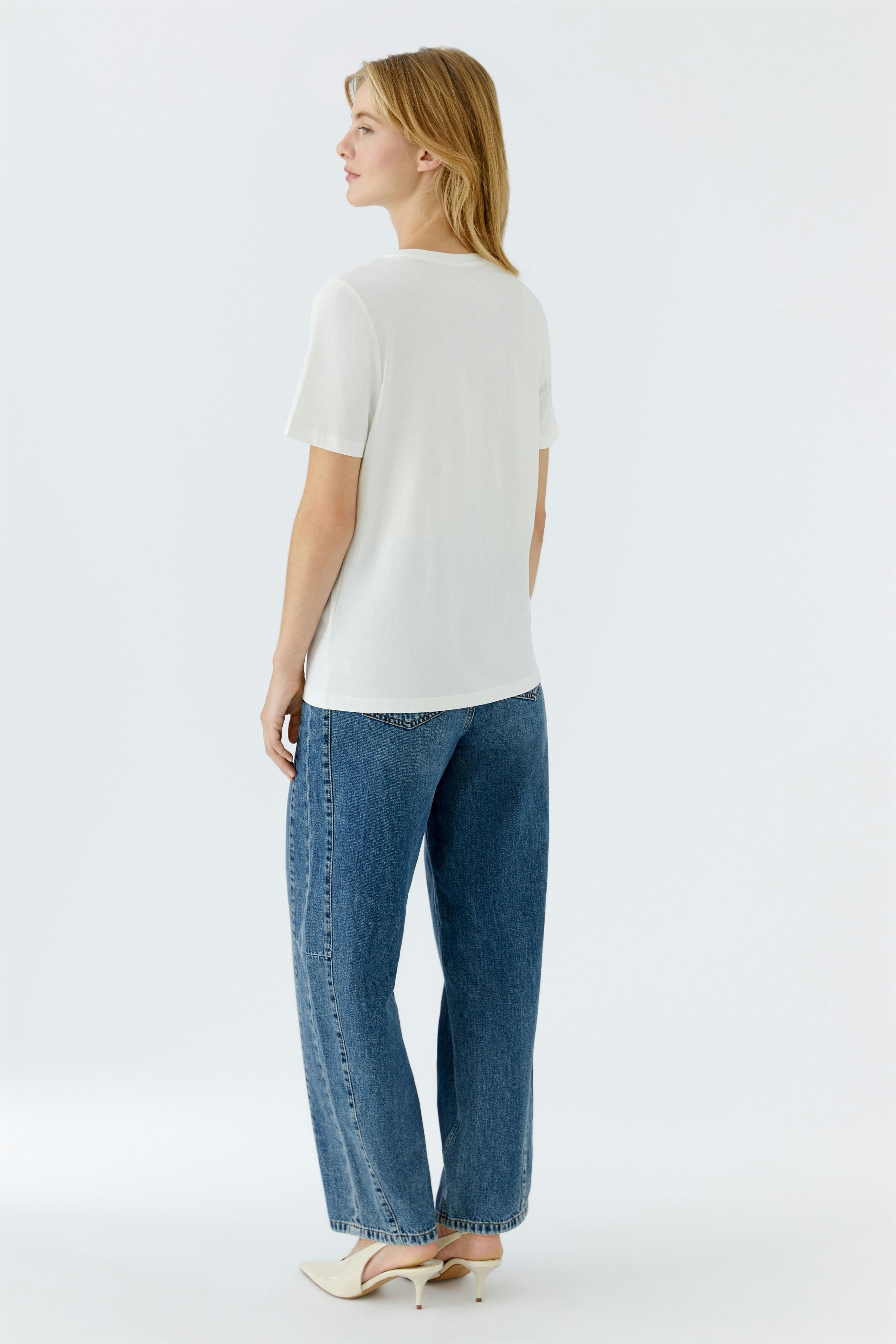 Casual women's T-shirt: A woman in a white T-shirt paired with relaxed-fit jeans.
