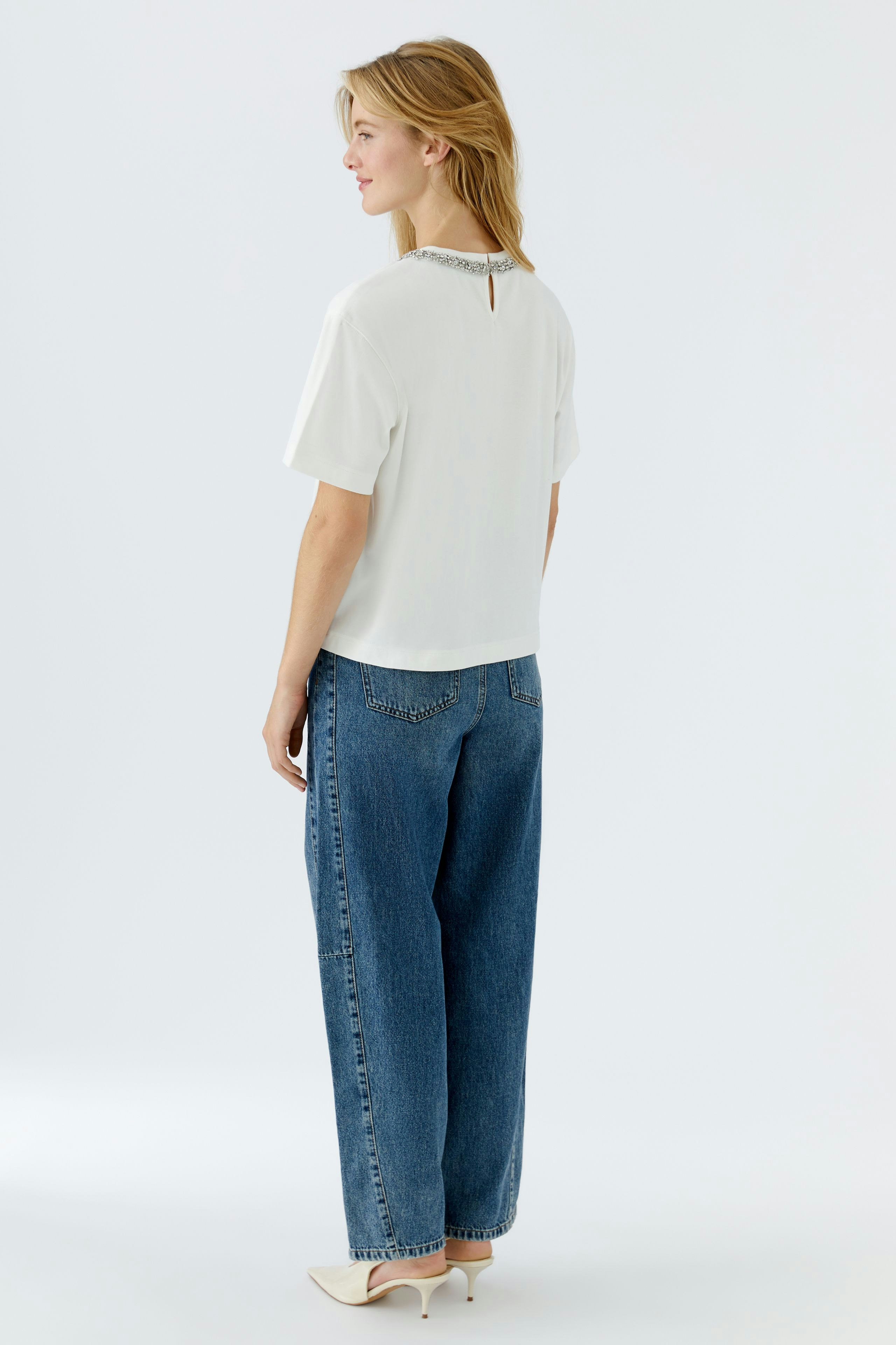 Casual women's T-shirt: A woman in a white T-shirt with a stylish neckline and relaxed fit.