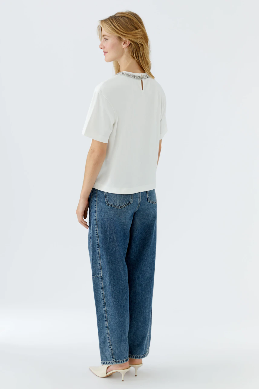 Casual women's T-shirt: A woman in a white T-shirt with a stylish neckline and relaxed fit.