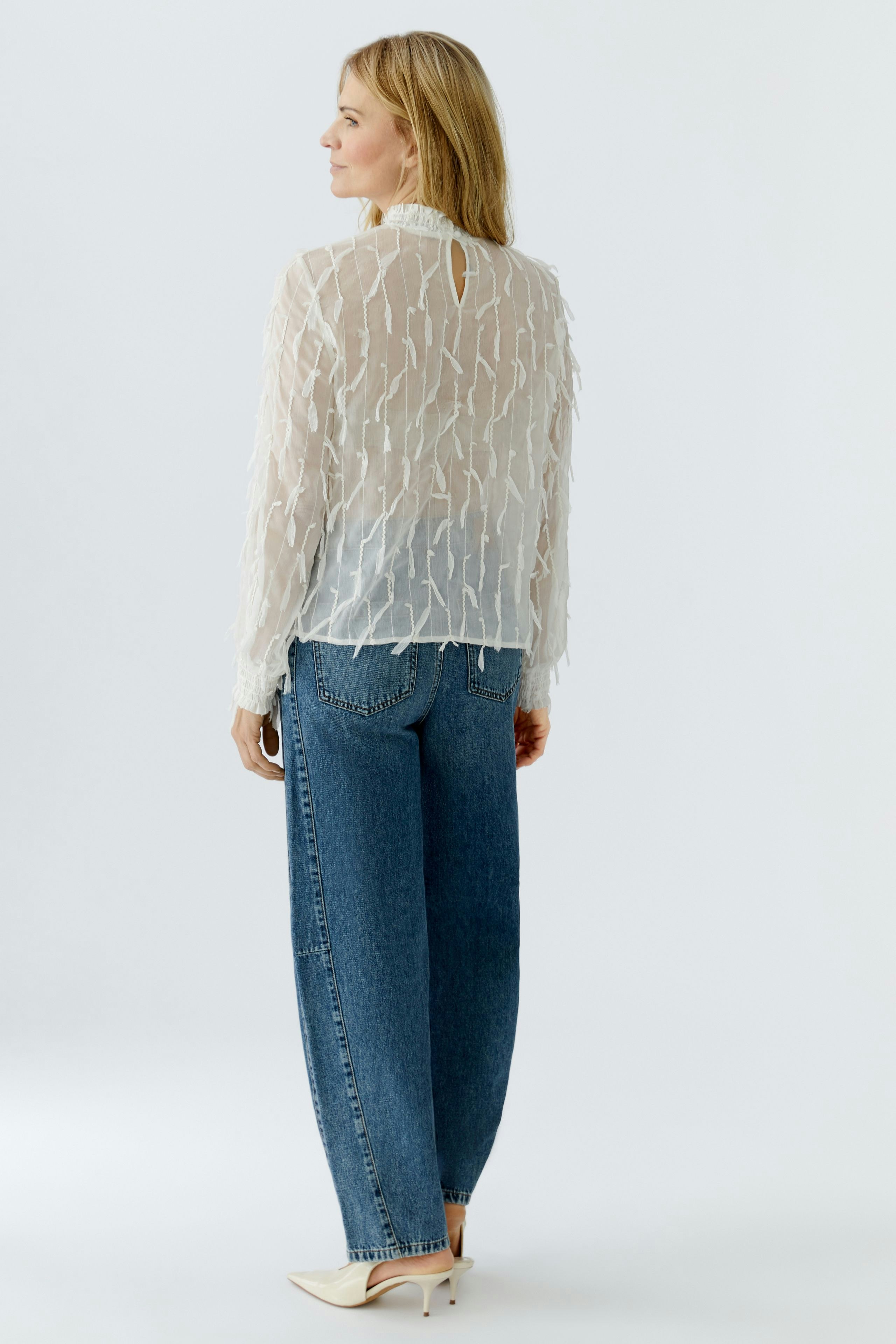 Lightweight women's blouse with textured design, paired with relaxed jeans, showcasing a casual style.