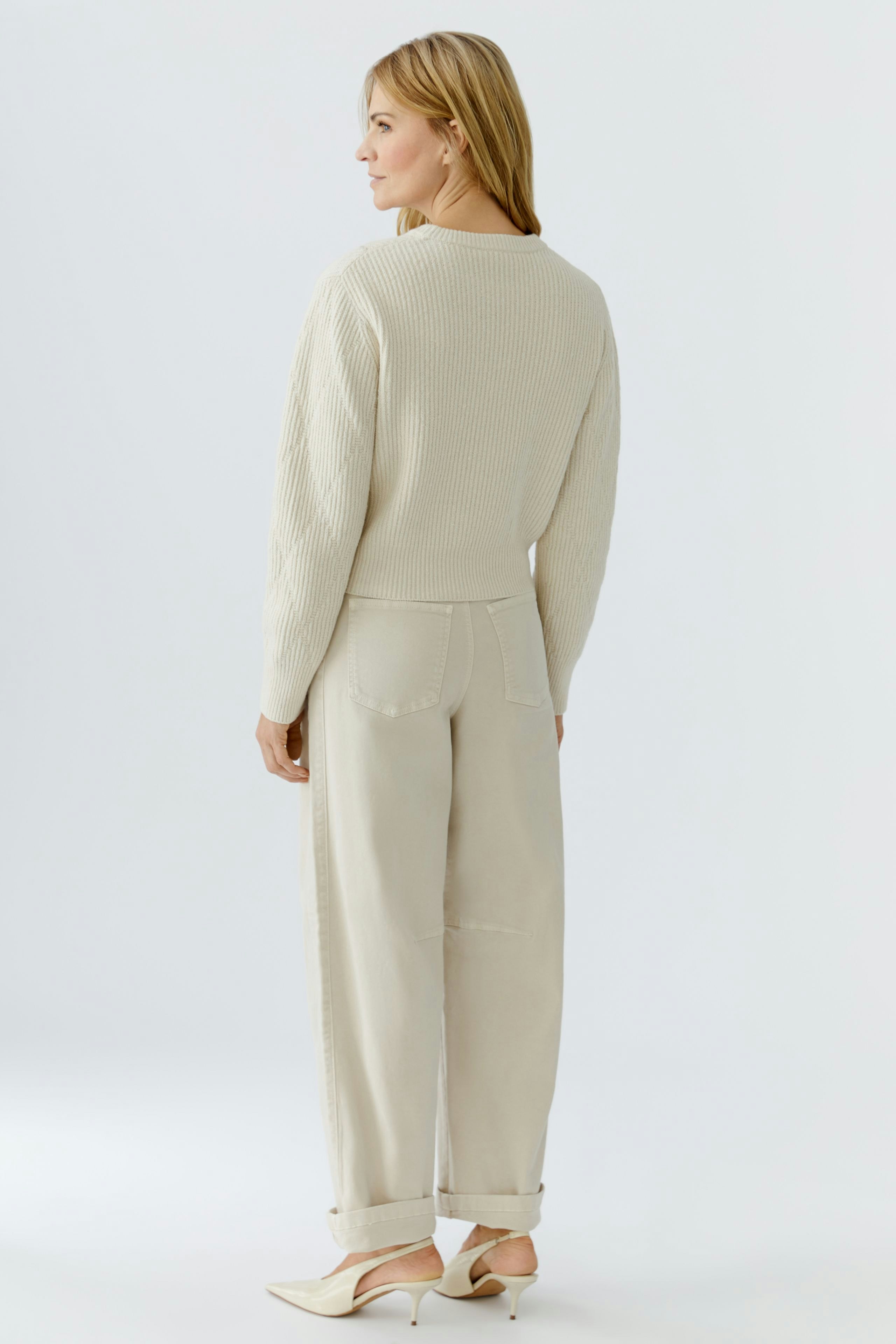 Casual women's pullover: A woman in a light beige textured pullover and relaxed-fit pants.