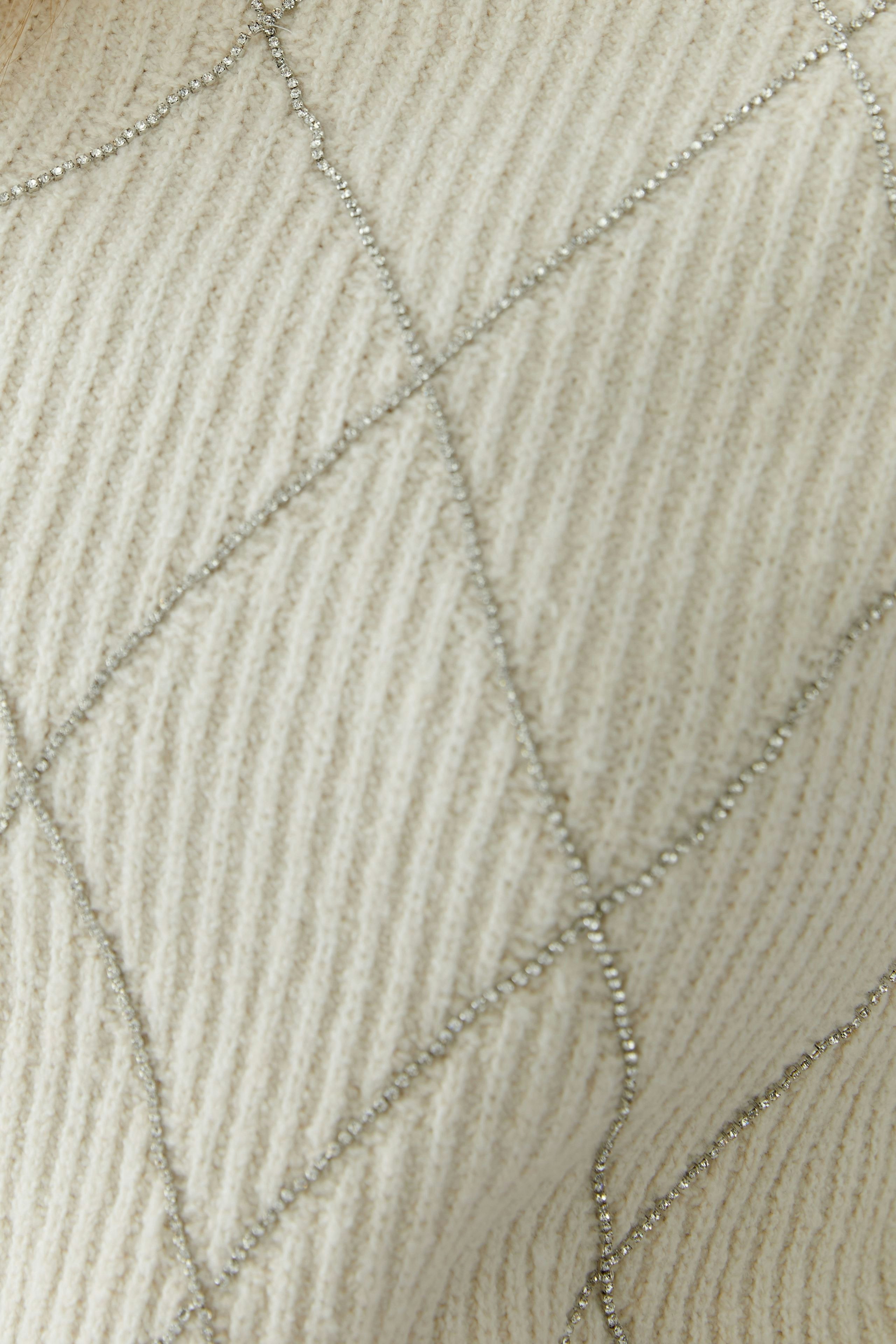 Casual women's pullover in cream with textured pattern and subtle shimmer details.