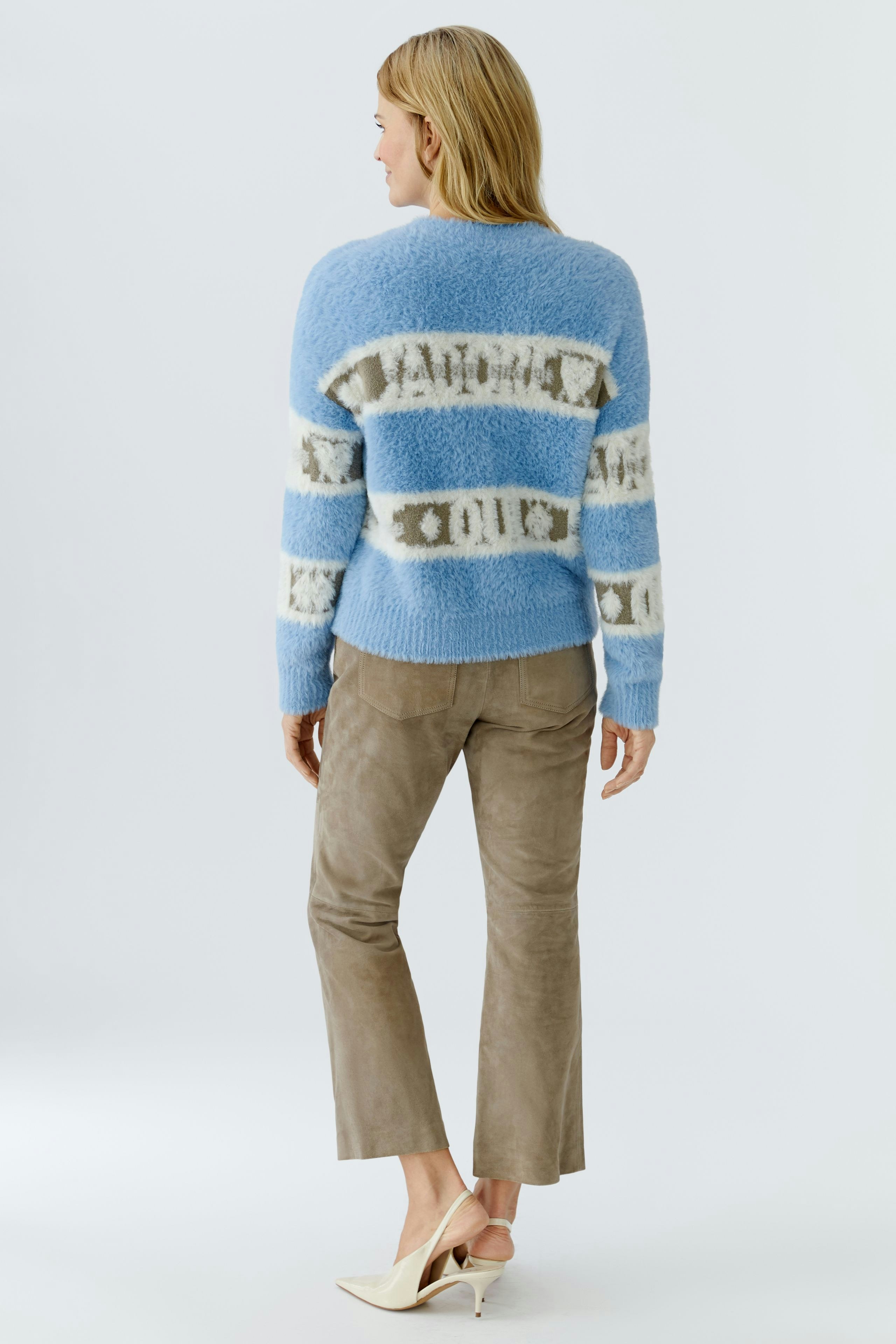 Casual women's pullover: A woman in a blue striped pullover with a relaxed fit, paired with light pants.