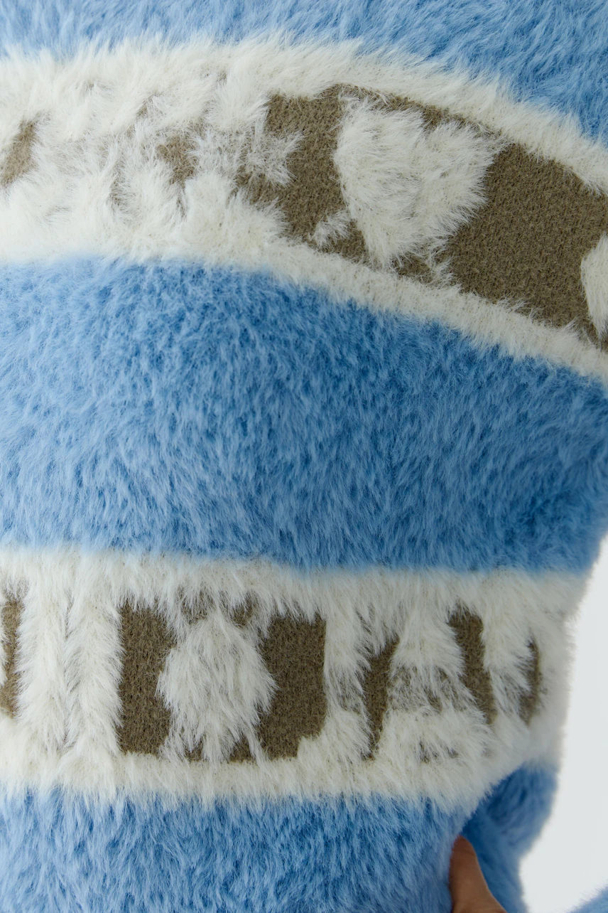Cozy women's pullover in soft blue with fluffy stripes and playful patterns.