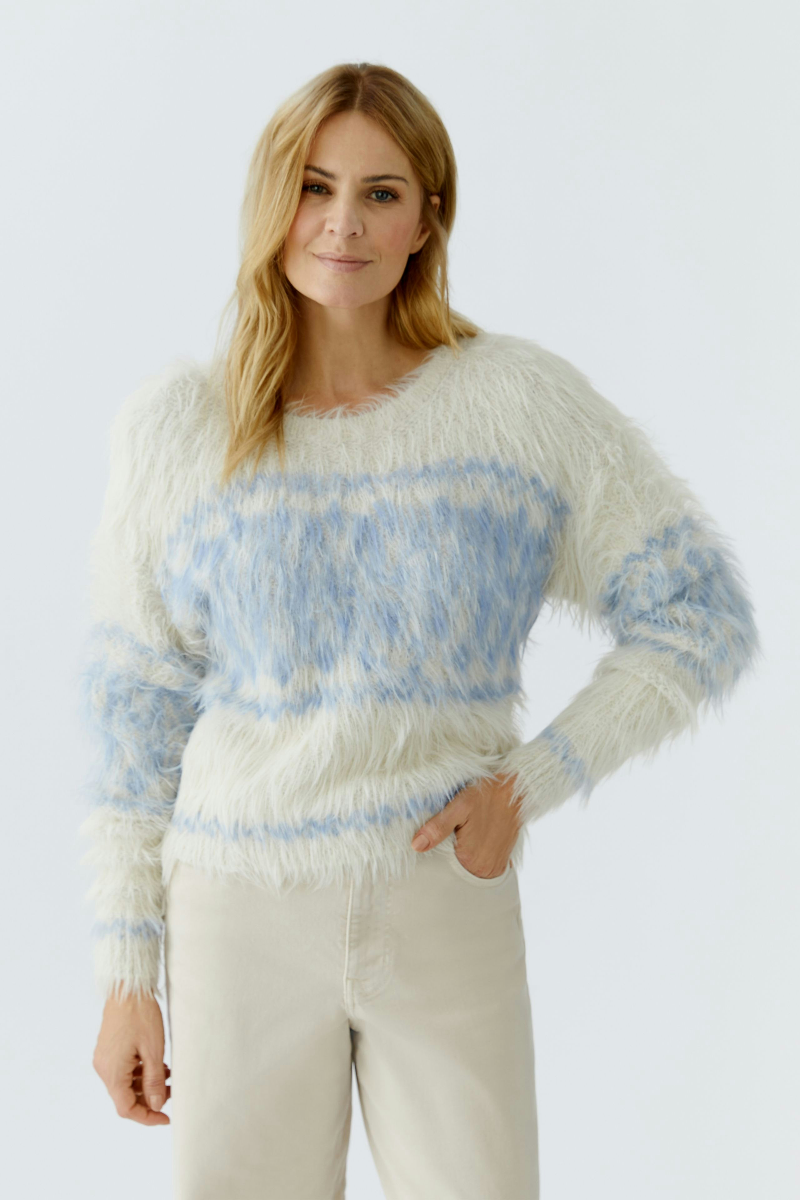 Cozy women's pullover: A woman in a fluffy white and blue pullover with relaxed fit.