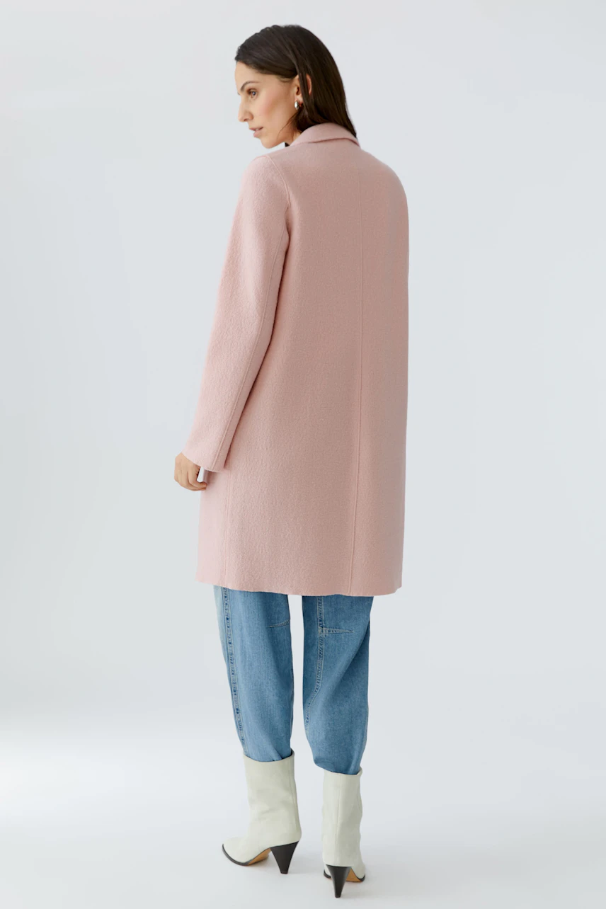 Modern women's wool coat: A woman in a pink wool coat, paired with casual jeans and stylish boots.