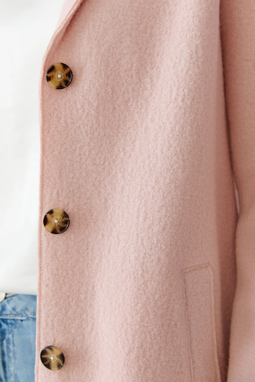 Stylish women's wool coat in soft pink with large buttons, perfect for casual wear.