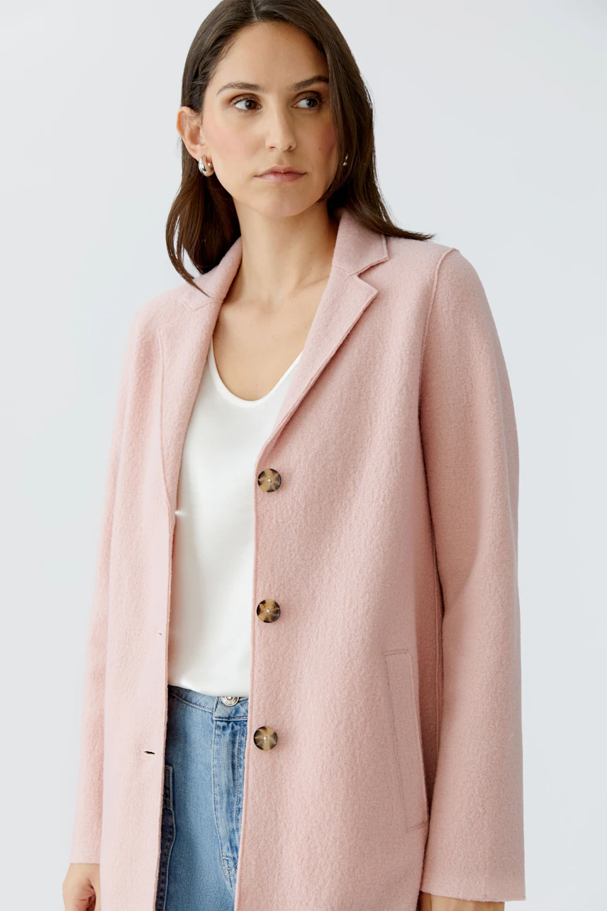Stylish women's wool coat in soft pink, featuring a tailored fit and button details.