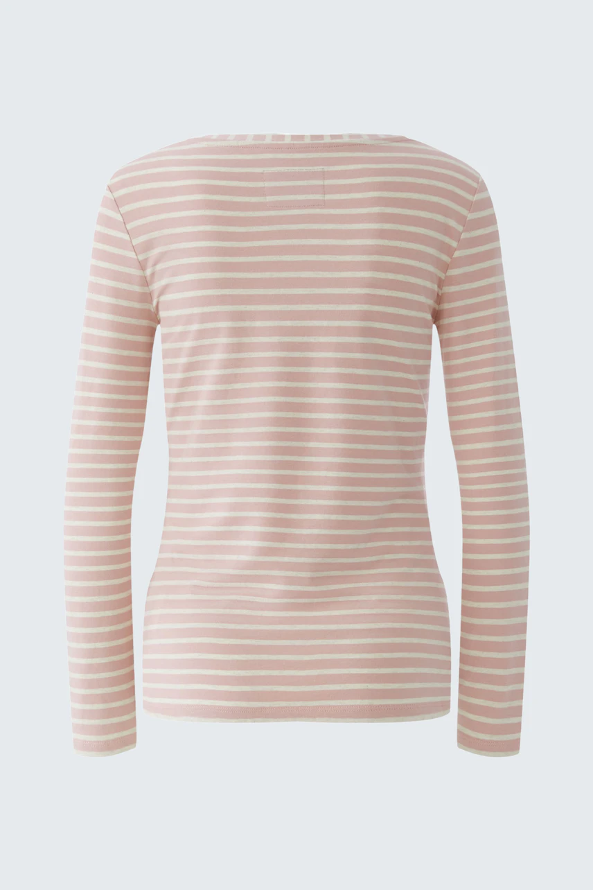Casual long-sleeve shirt: A woman in a pink striped pullover, showcasing a relaxed fit and comfortable style.