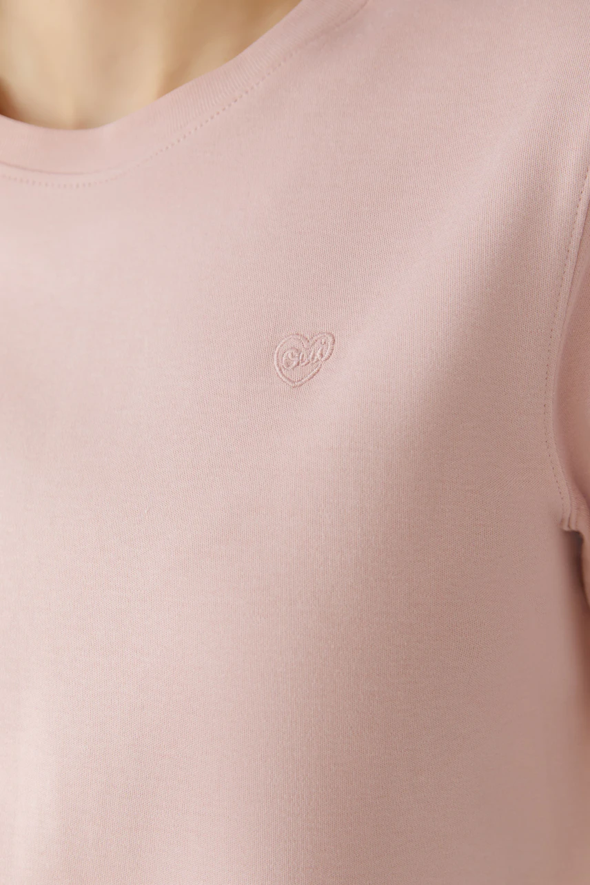 Bequemes Damen-T-Shirt in zartem Rosa mit dezentem Logo. Ideal für den Alltag.