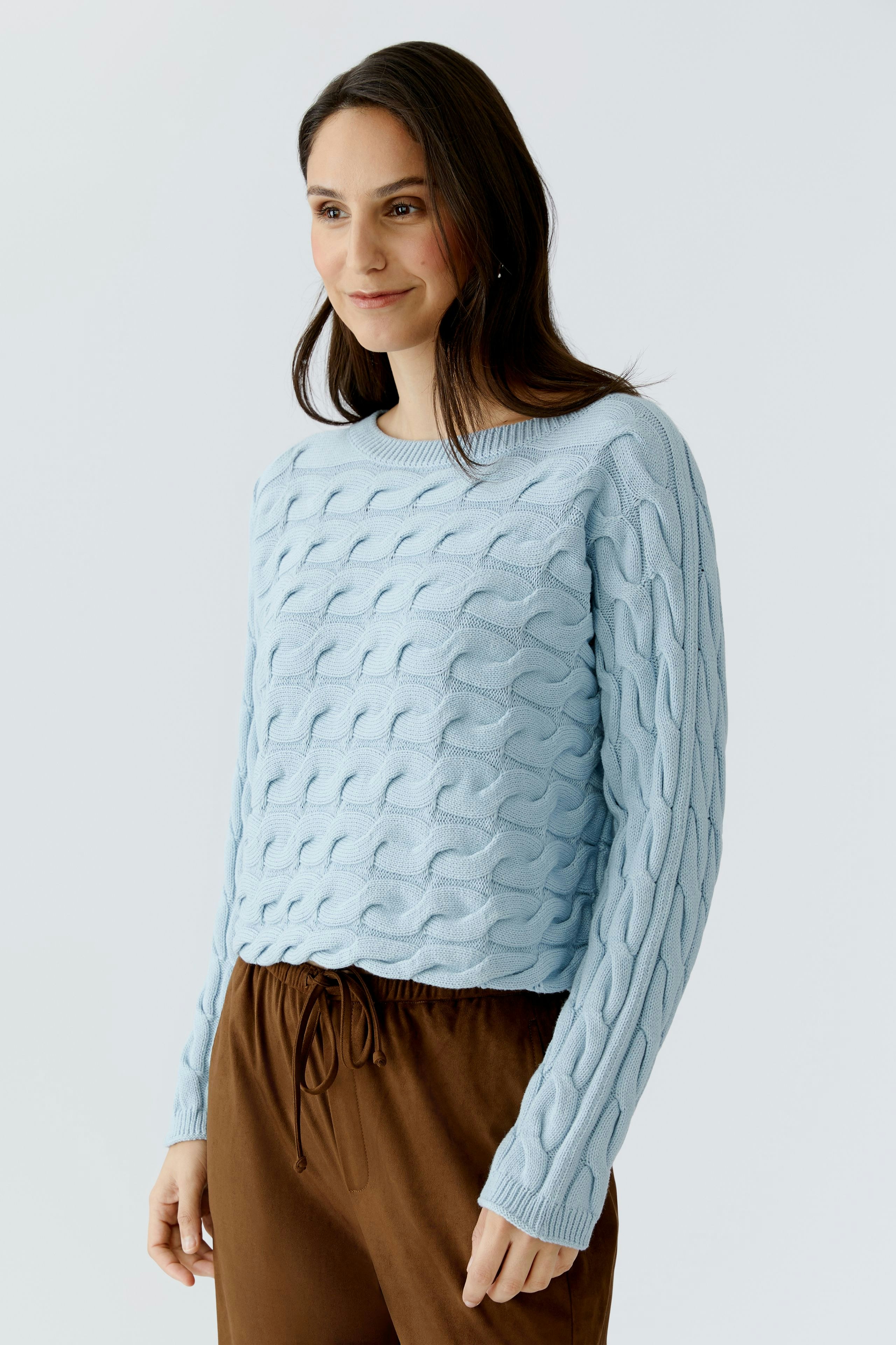Damen-Pullover: Frau in hellblauem, strukturiertem Pullover mit lässigem Schnitt und Rundhalsausschnitt.