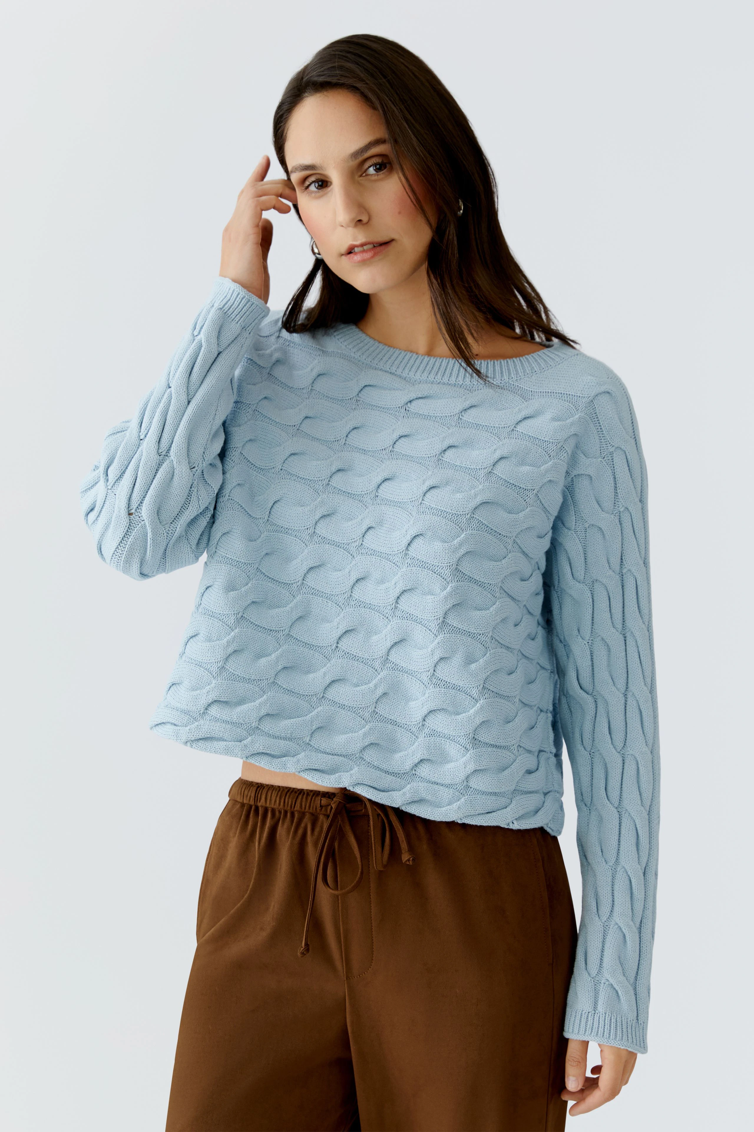 Damen-Pullover: Junge Frau in hellblauem, strukturiertem Pullover mit lässigem Schnitt.