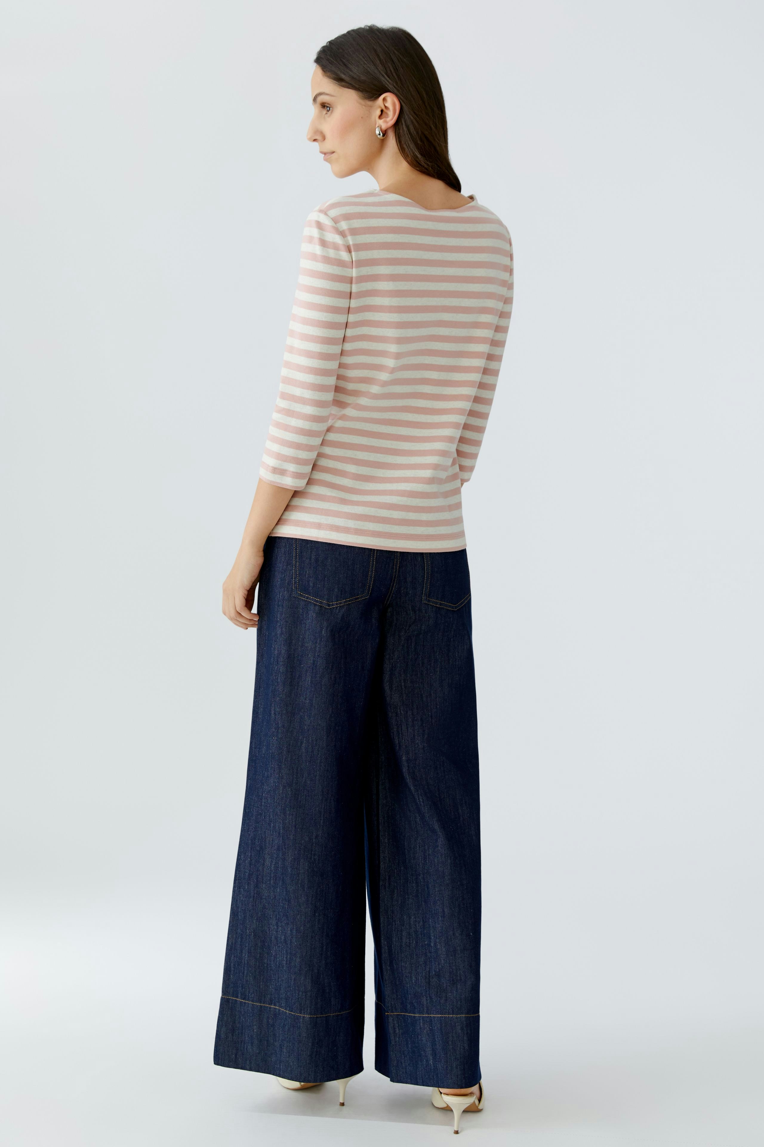 Casual women's T-shirt: A woman in a striped shirt with three-quarter sleeves and wide-leg jeans.
