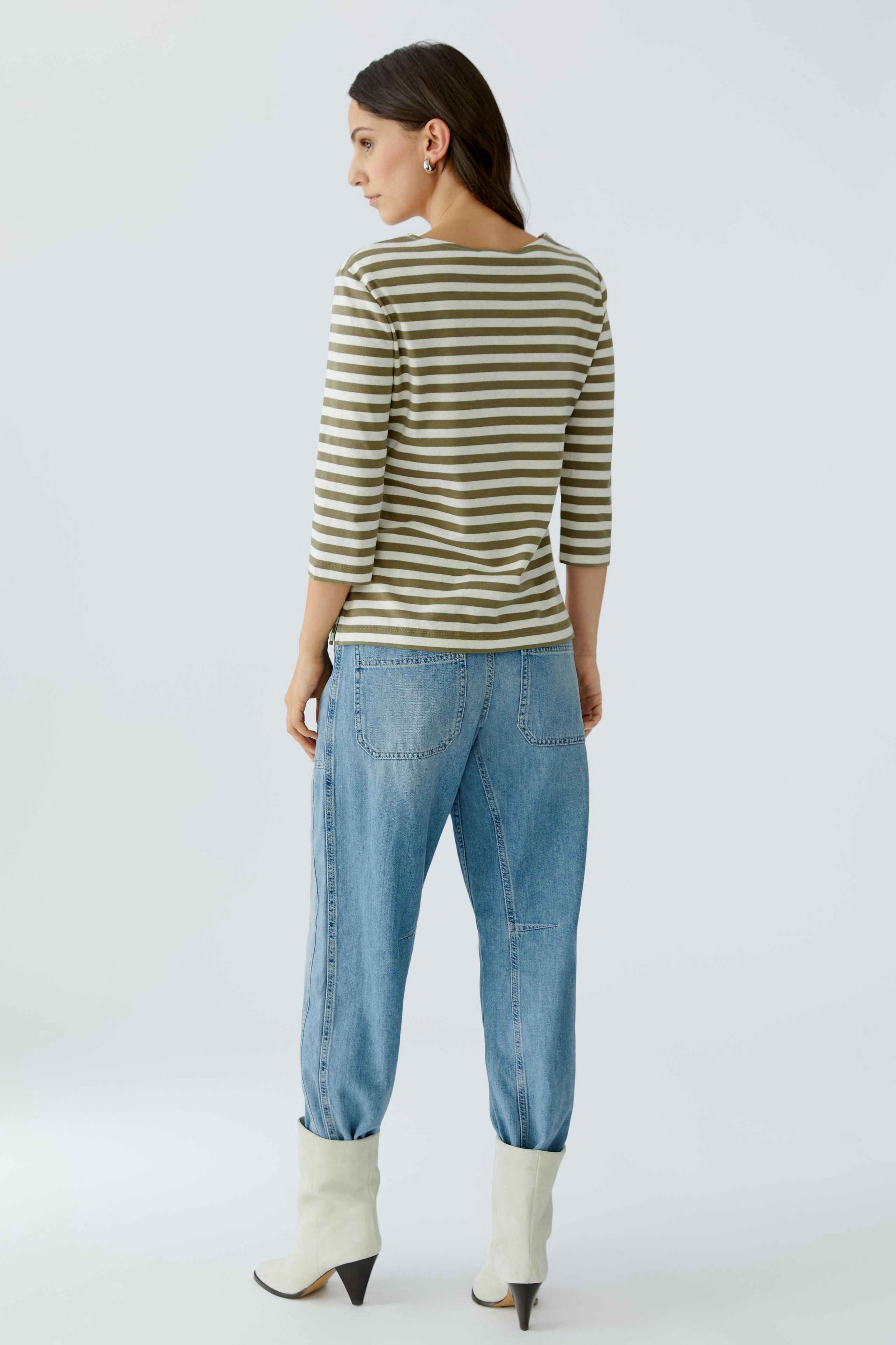 Casual women's T-shirt: Young woman in a striped top with three-quarter sleeves and relaxed-fit jeans.