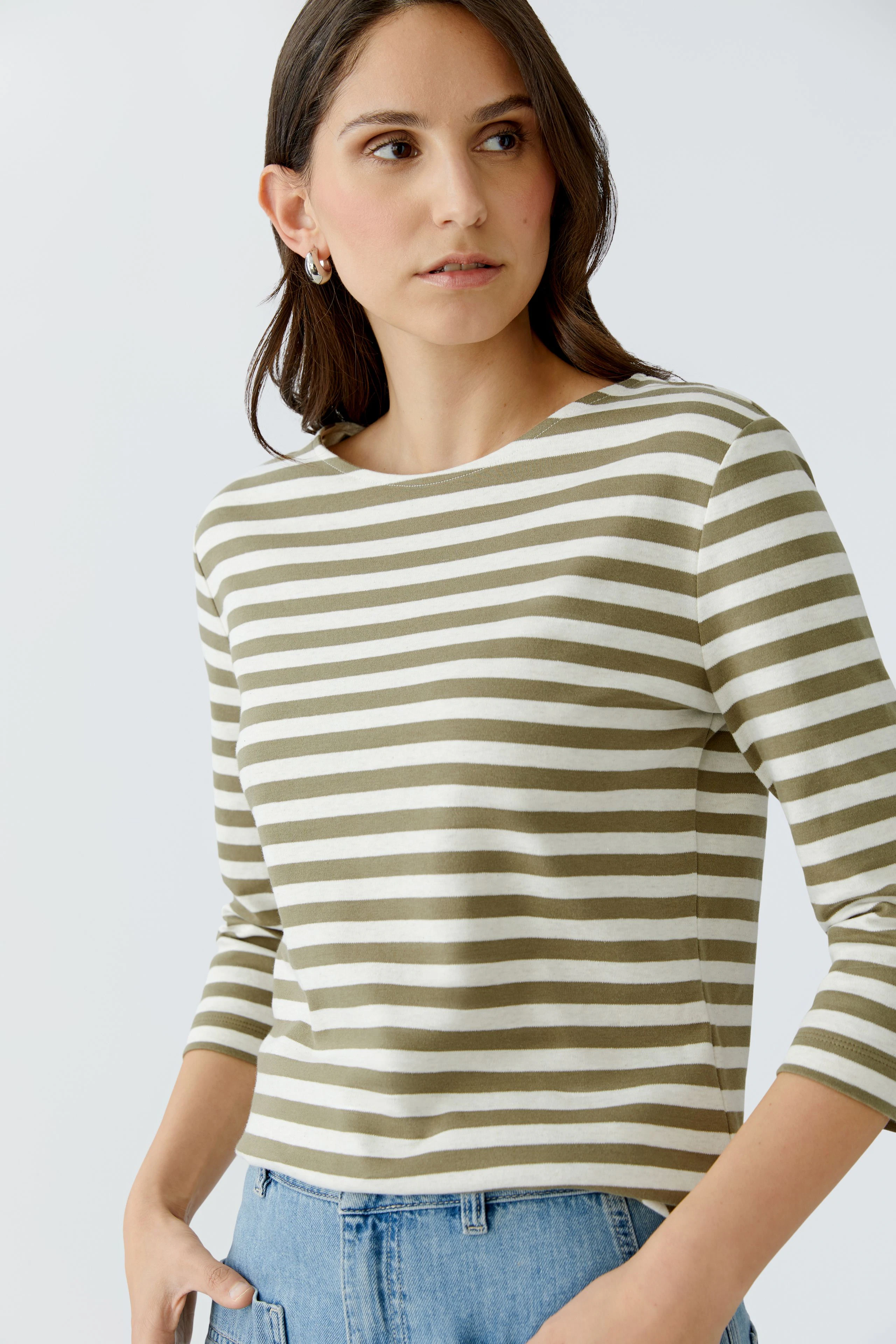 Casual women's T-shirt: Young woman in a striped top with three-quarter sleeves, looking confidently.