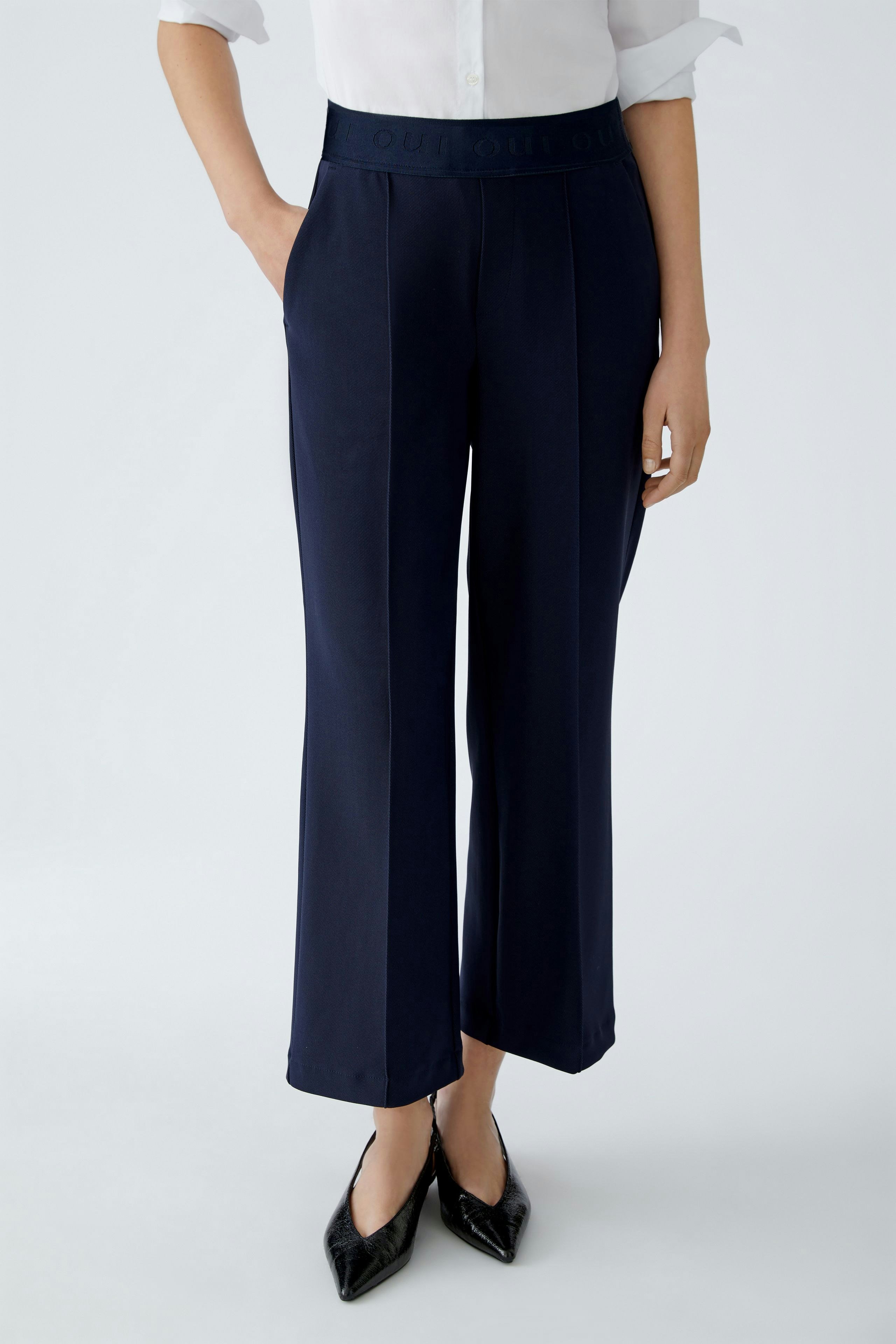 Modern culotte: Woman in navy wide-leg pants with a comfortable waistband, styled with a classic shirt.