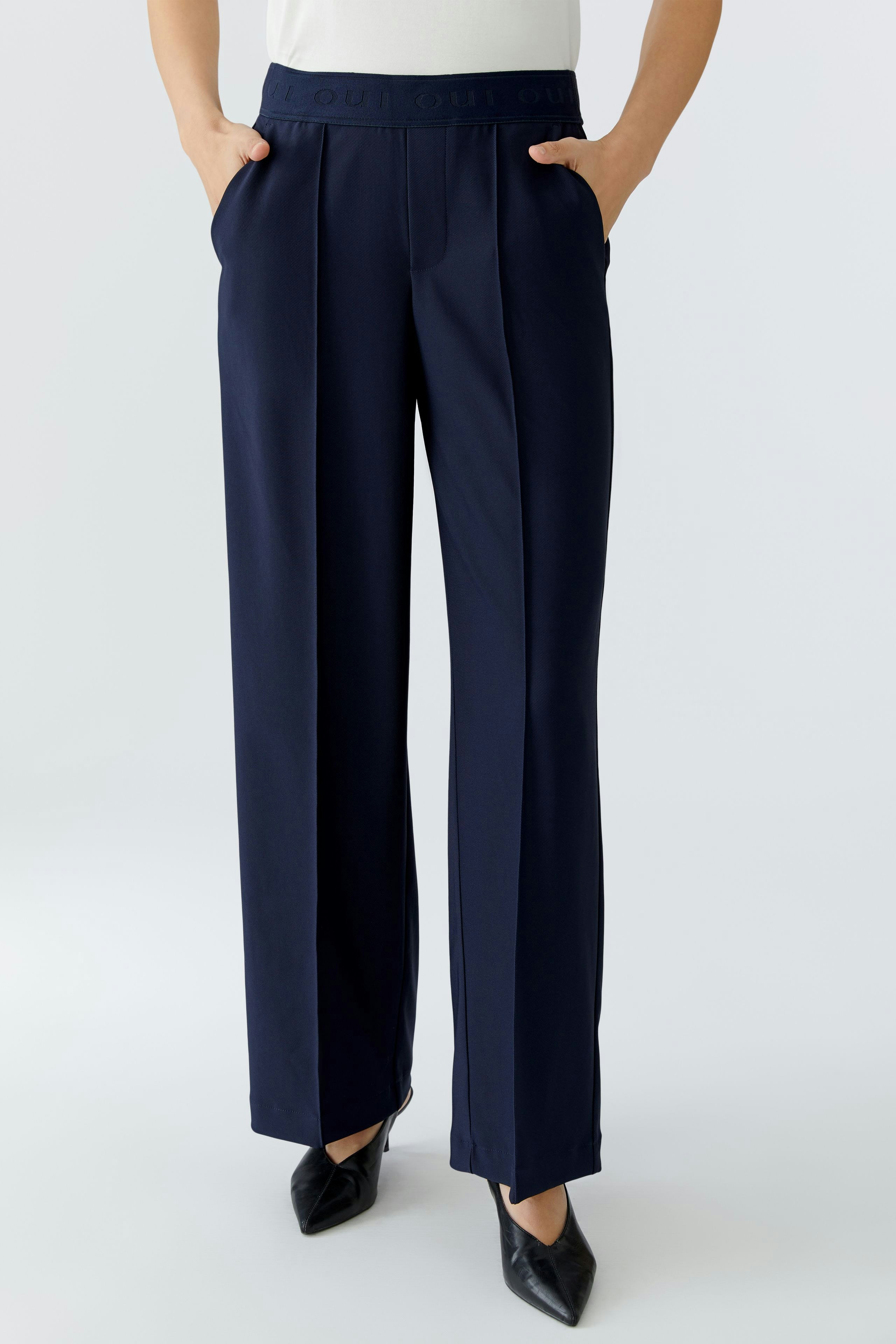 Bequeme Damen-Hose: Frau in navyfarbener Hose mit weitem Schnitt und praktischen Taschen.