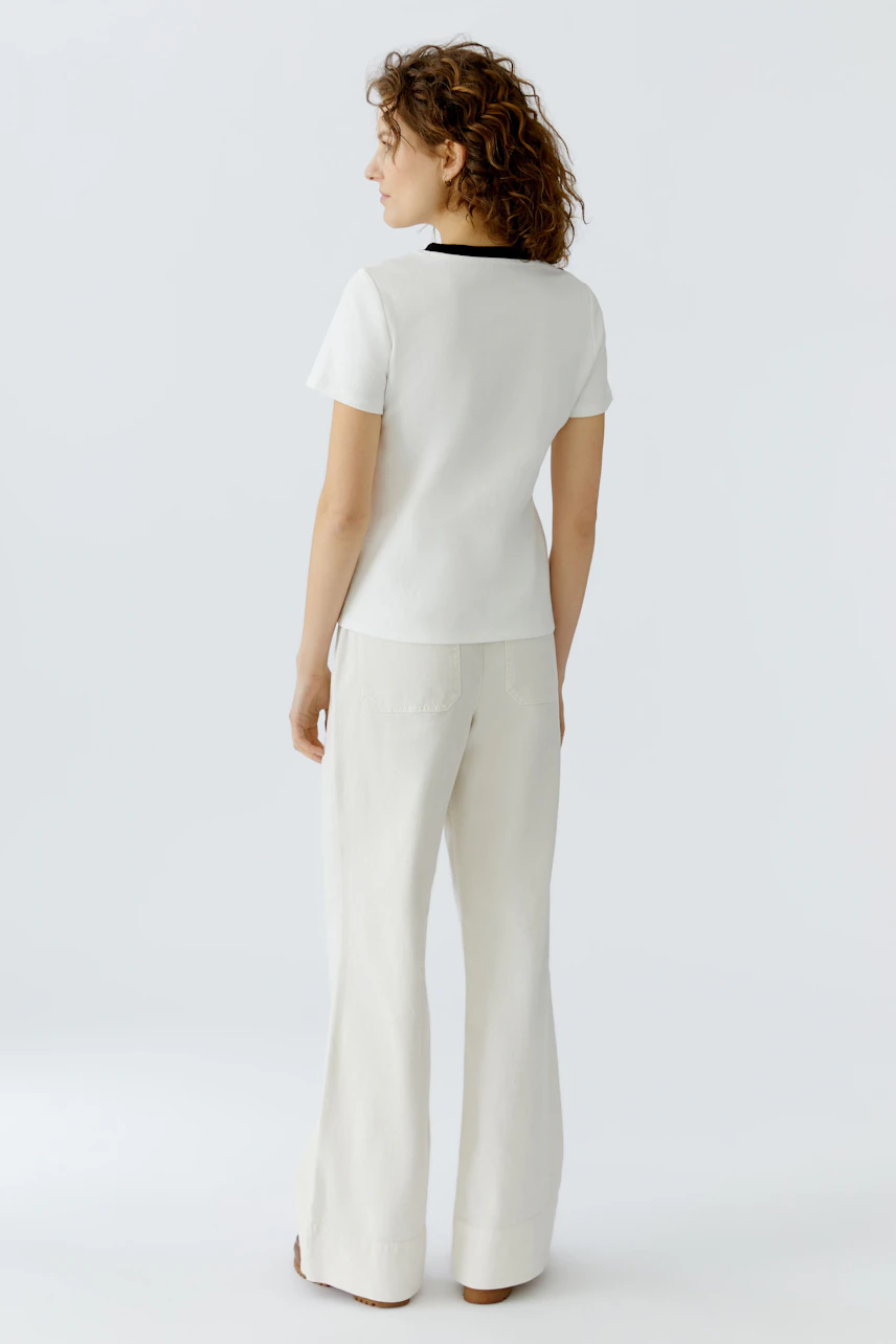 Casual women's T-shirt: A woman in a white T-shirt with a black collar, viewed from the back.