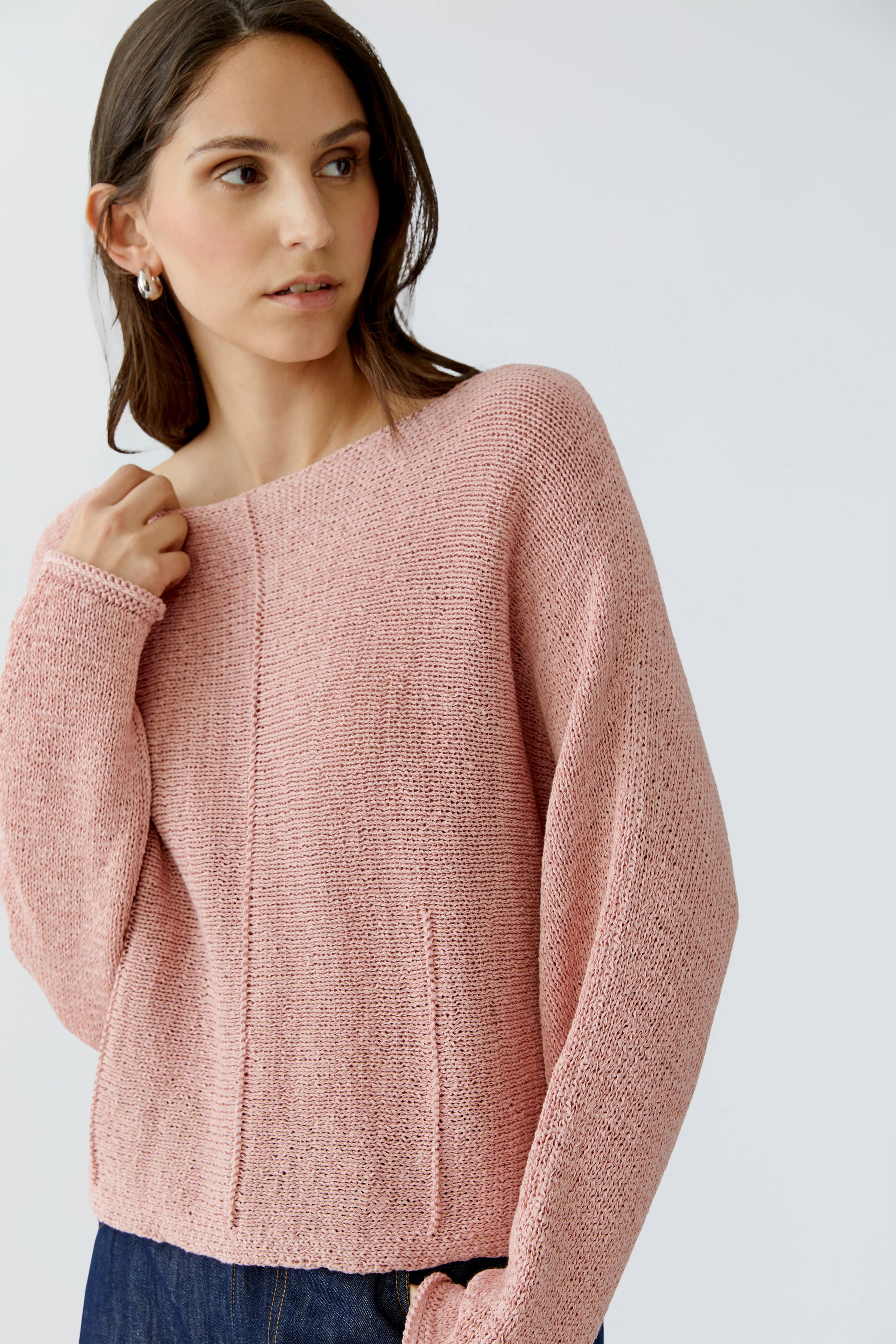 Casual women's pullover: Young woman in a soft pink knit pullover with a relaxed fit.