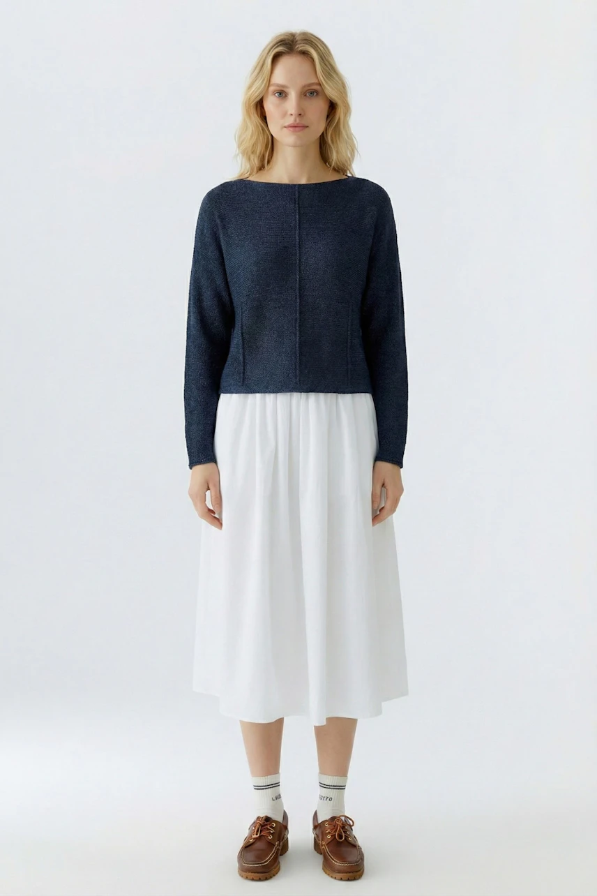 Casual women's pullover: A woman in a navy pullover paired with a white skirt, showcasing a relaxed style.