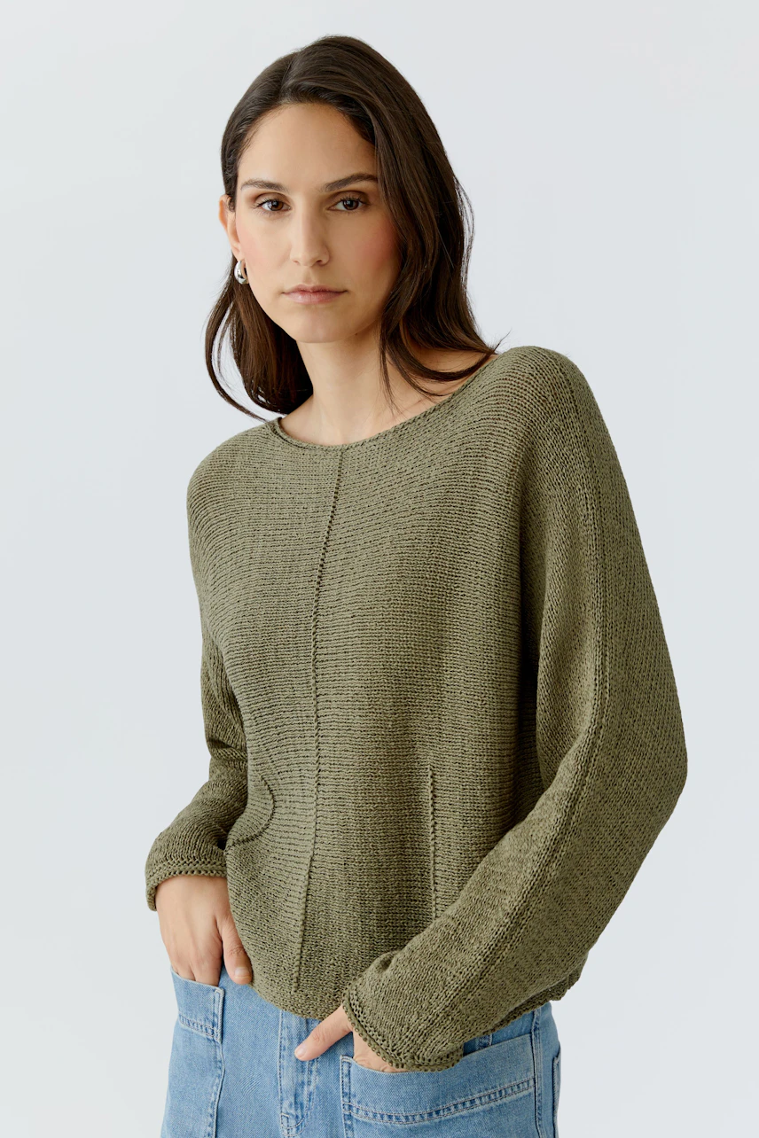 Casual women's pullover: A woman in a relaxed olive green pullover with a round neckline.