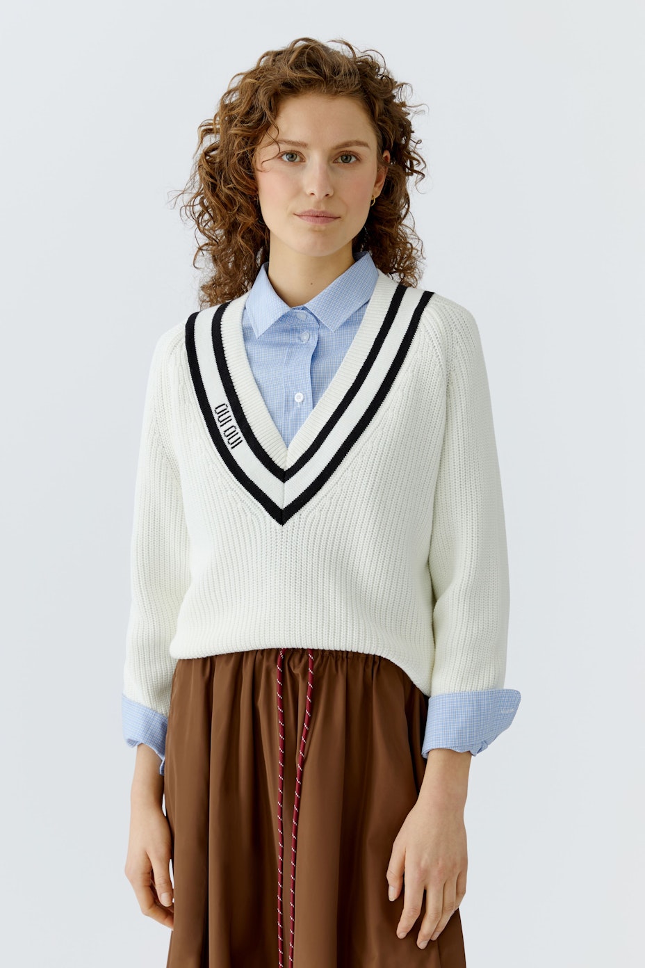 Casual women's pullover: White knit pullover with a V-neck and black stripes.