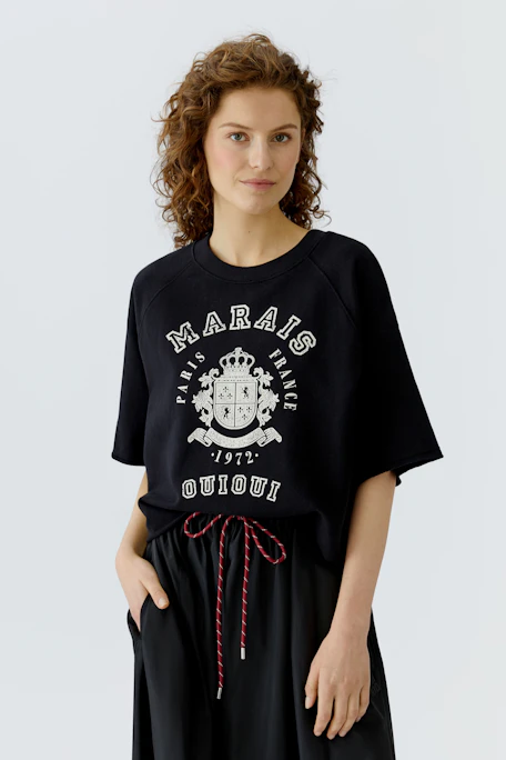 Casual women's pullover: Black cropped sweatshirt with bold white lettering, perfect for everyday wear.