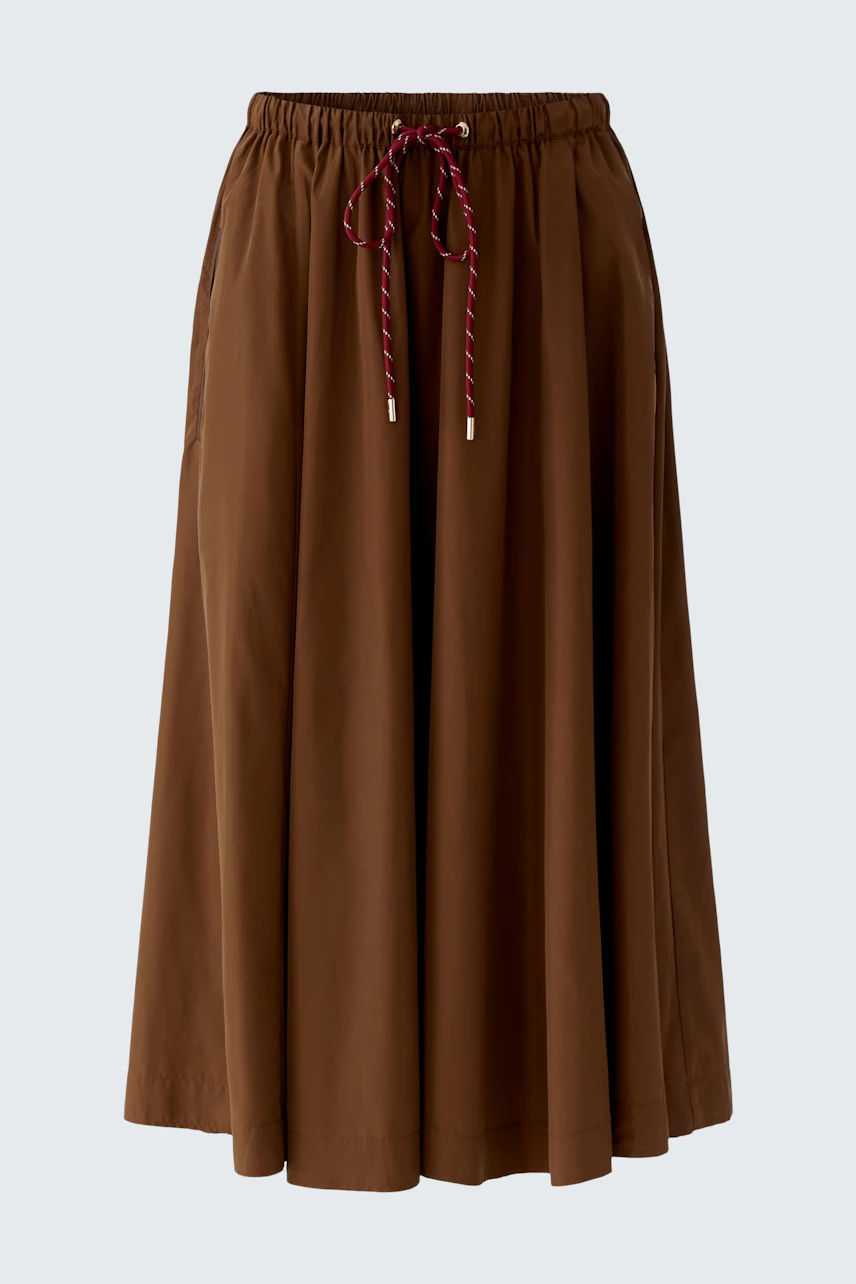 Casual A-line skirt: A woman in a brown A-line skirt with a drawstring waist, perfect for everyday wear.