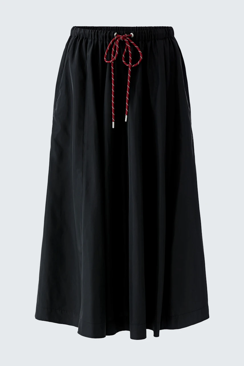 Casual A-line skirt: A woman in a black A-line skirt with a drawstring waist, perfect for everyday wear.