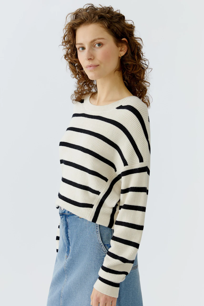 Casual women's pullover: Young woman in a striped pullover with a relaxed fit and denim skirt.