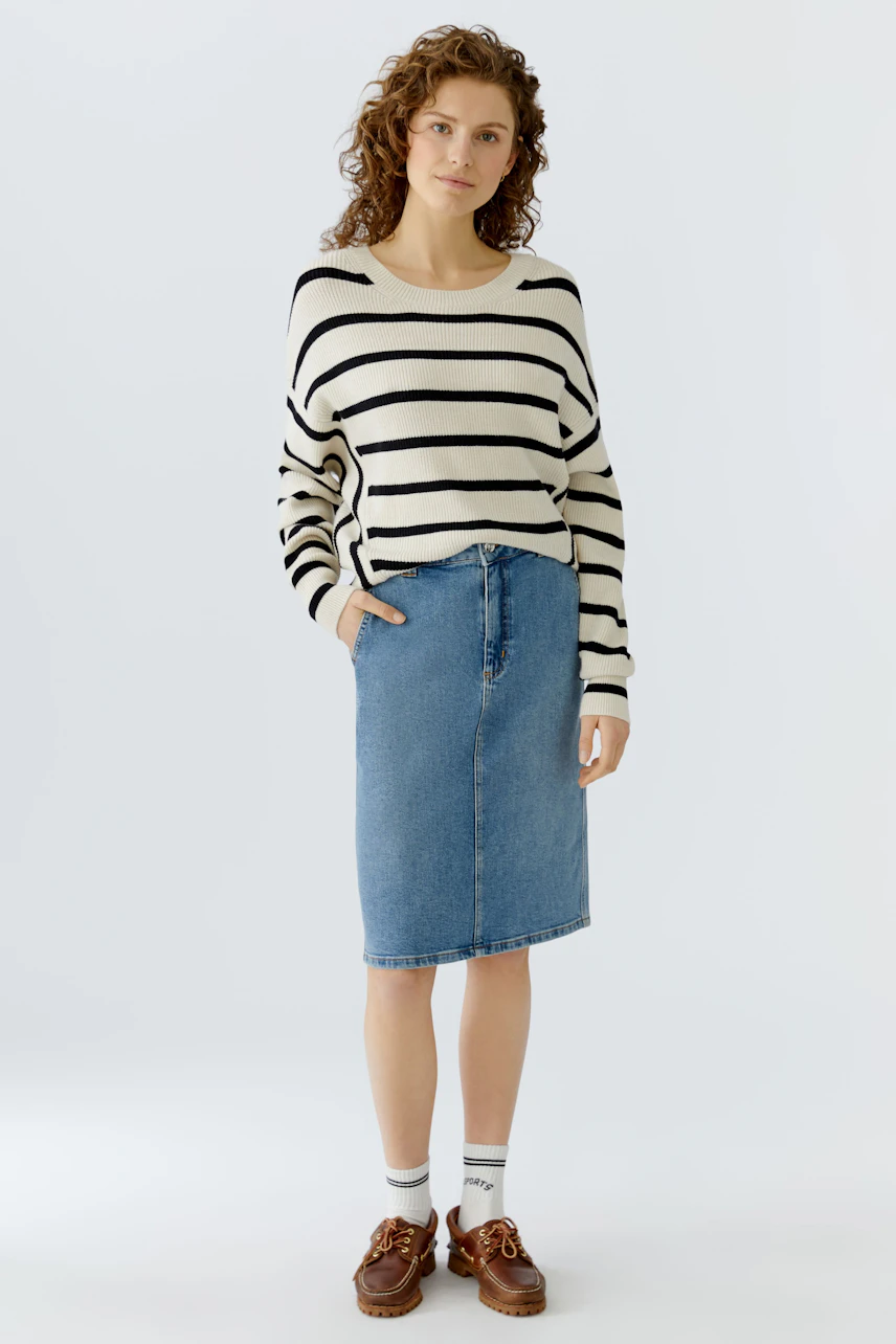 Casual women's pullover: A woman in a striped pullover paired with a denim skirt, exuding a relaxed vibe.