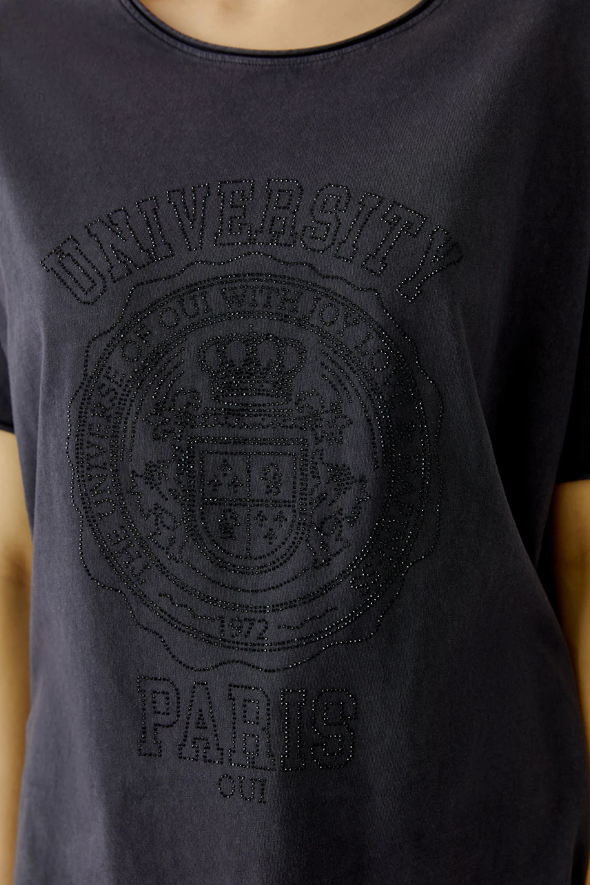 Casual women's T-shirt: Close-up of a woman wearing a dark T-shirt with a university print.