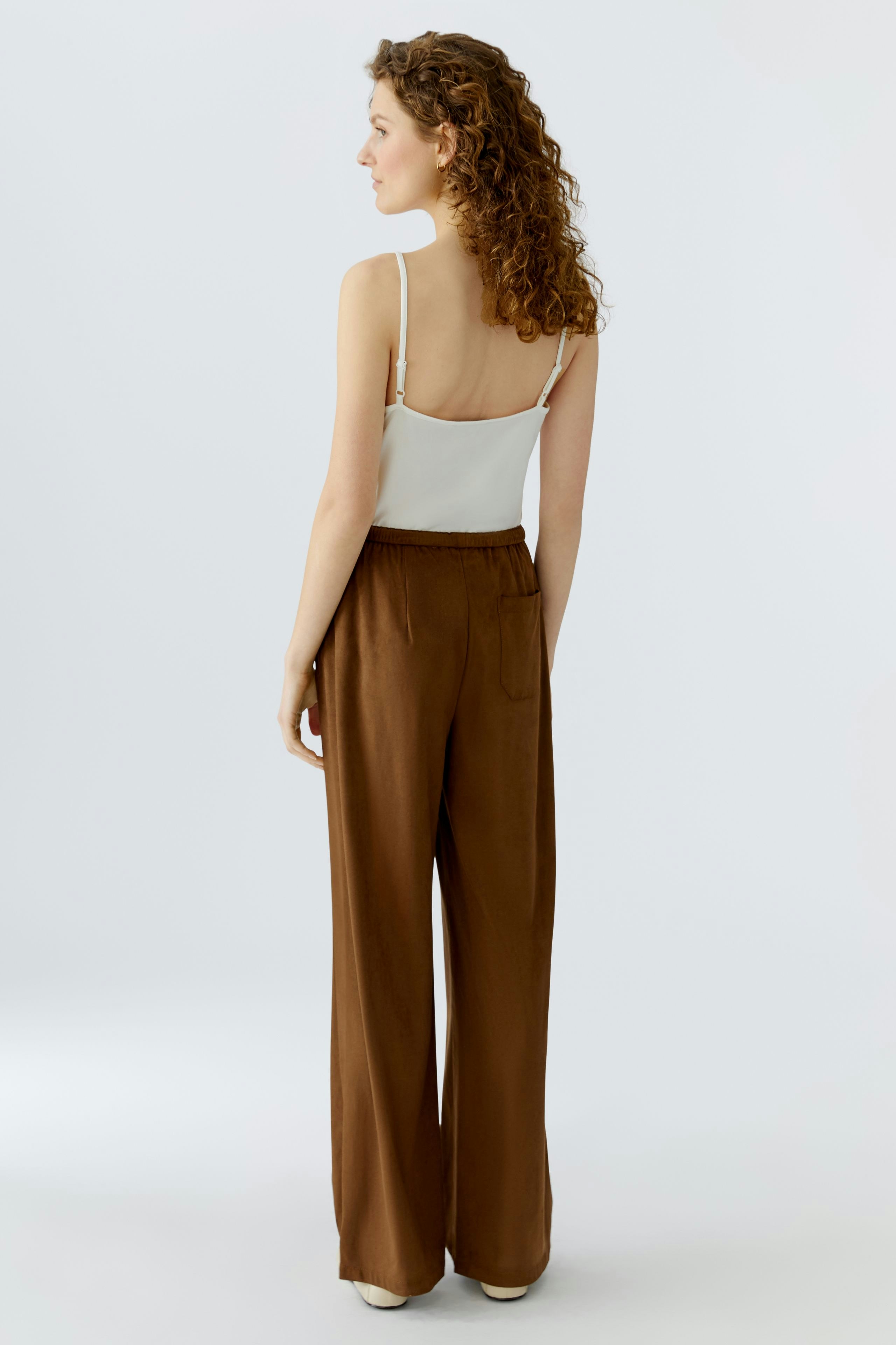 Stylish women's faux leather pants: A woman in brown wide-leg pants with a relaxed fit.