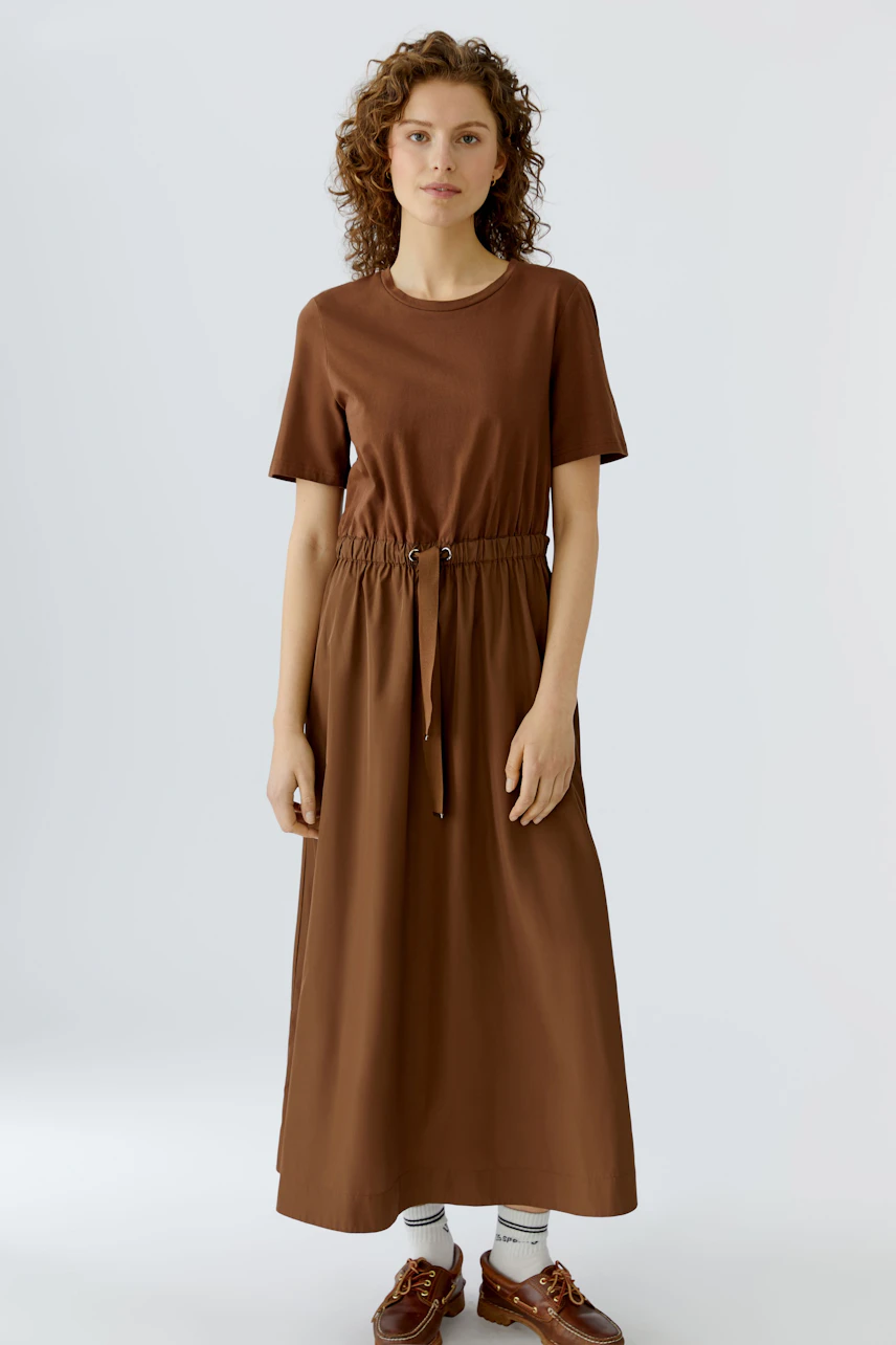 Casual brown maxi dress: Woman in a short-sleeve dress with an adjustable waist, perfect for everyday wear.