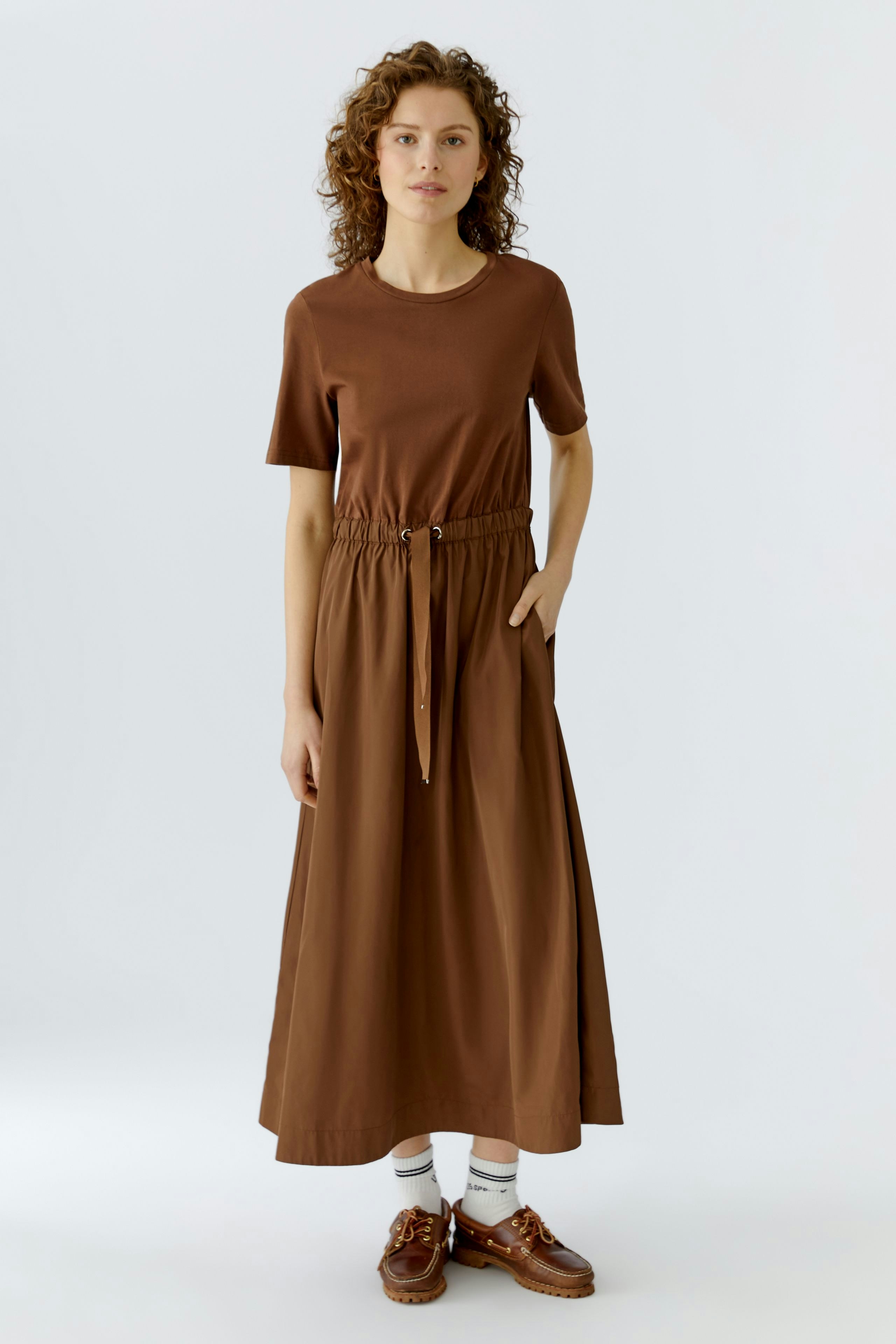 Casual brown maxi dress: Woman in a short-sleeve dress with an elastic waist and relaxed fit.