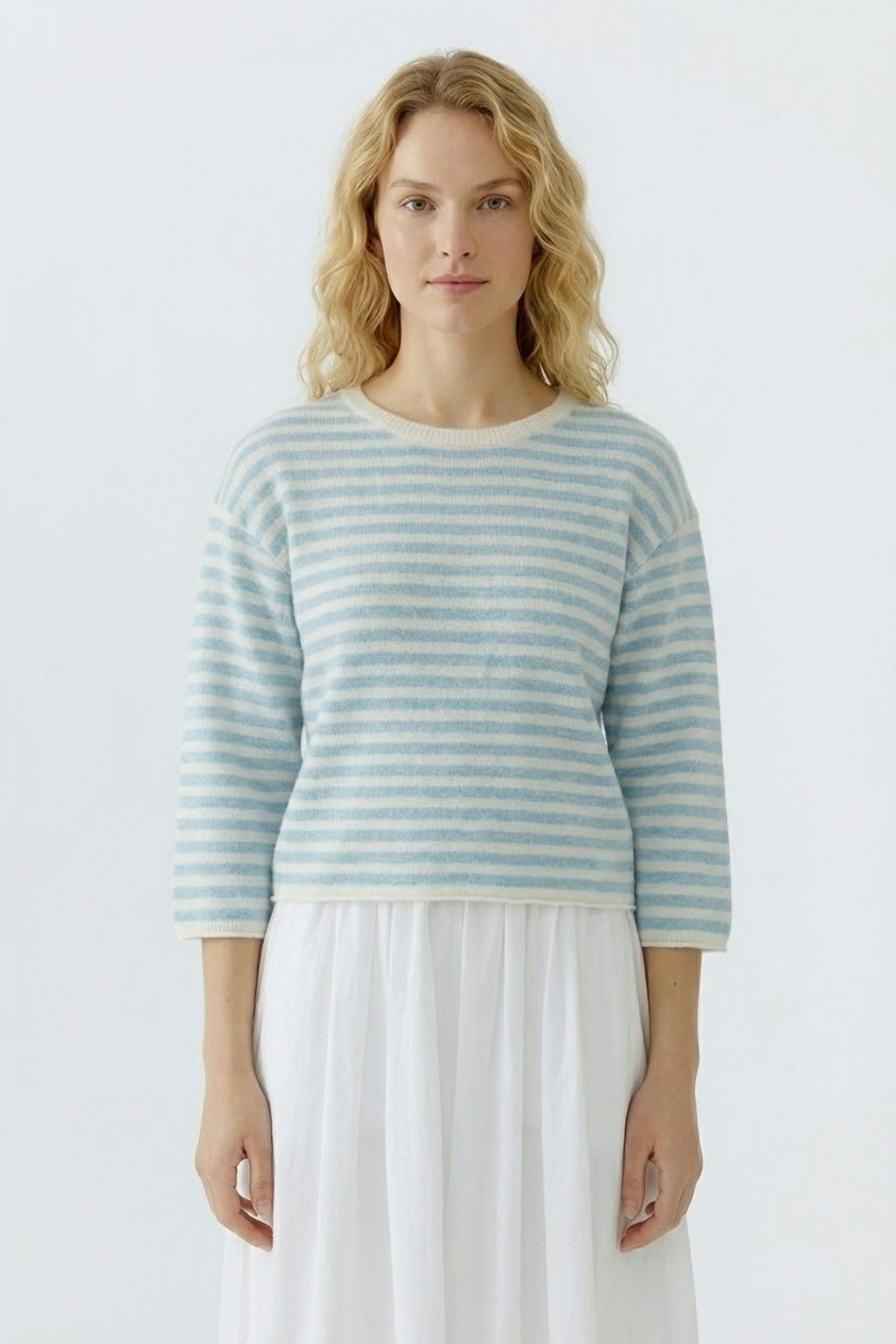 Damen-Pullover: Frau in gestreiftem Pullover in Blau und Weiß, lässig und bequem.