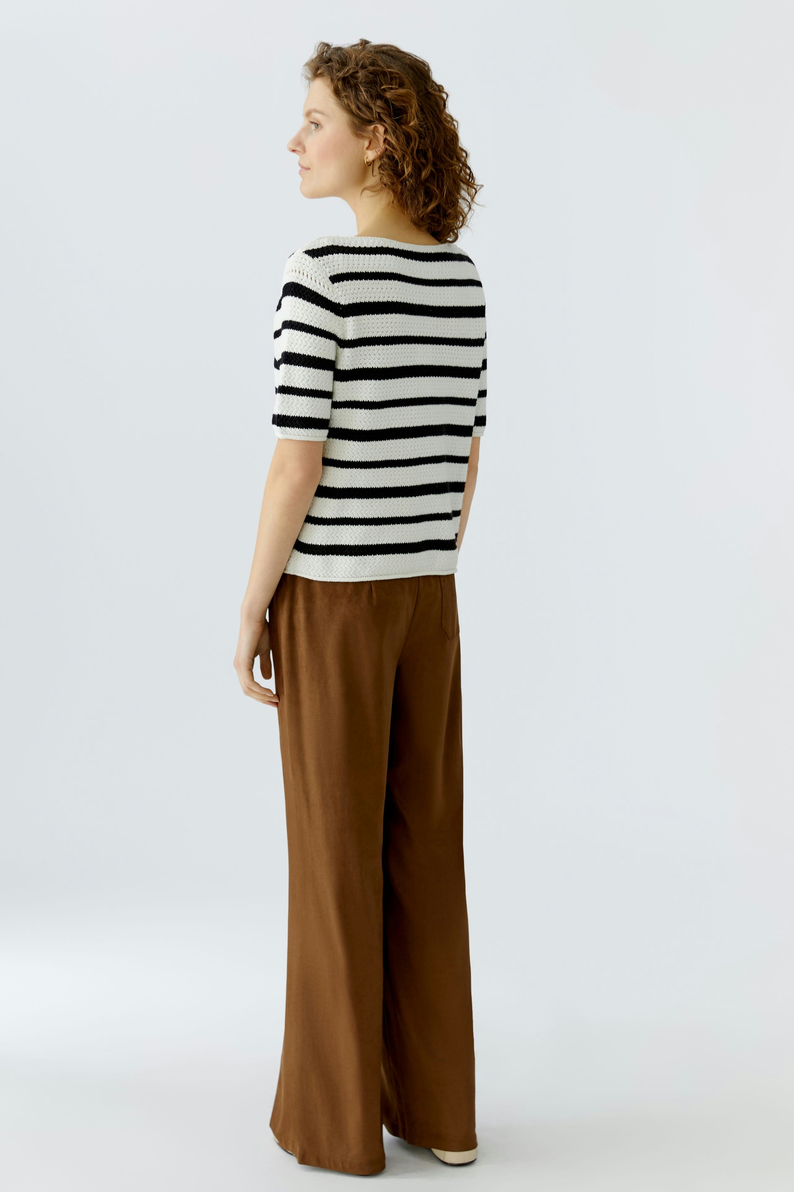 Casual women's pullover: A woman in a striped pullover with short sleeves and relaxed fit pants.