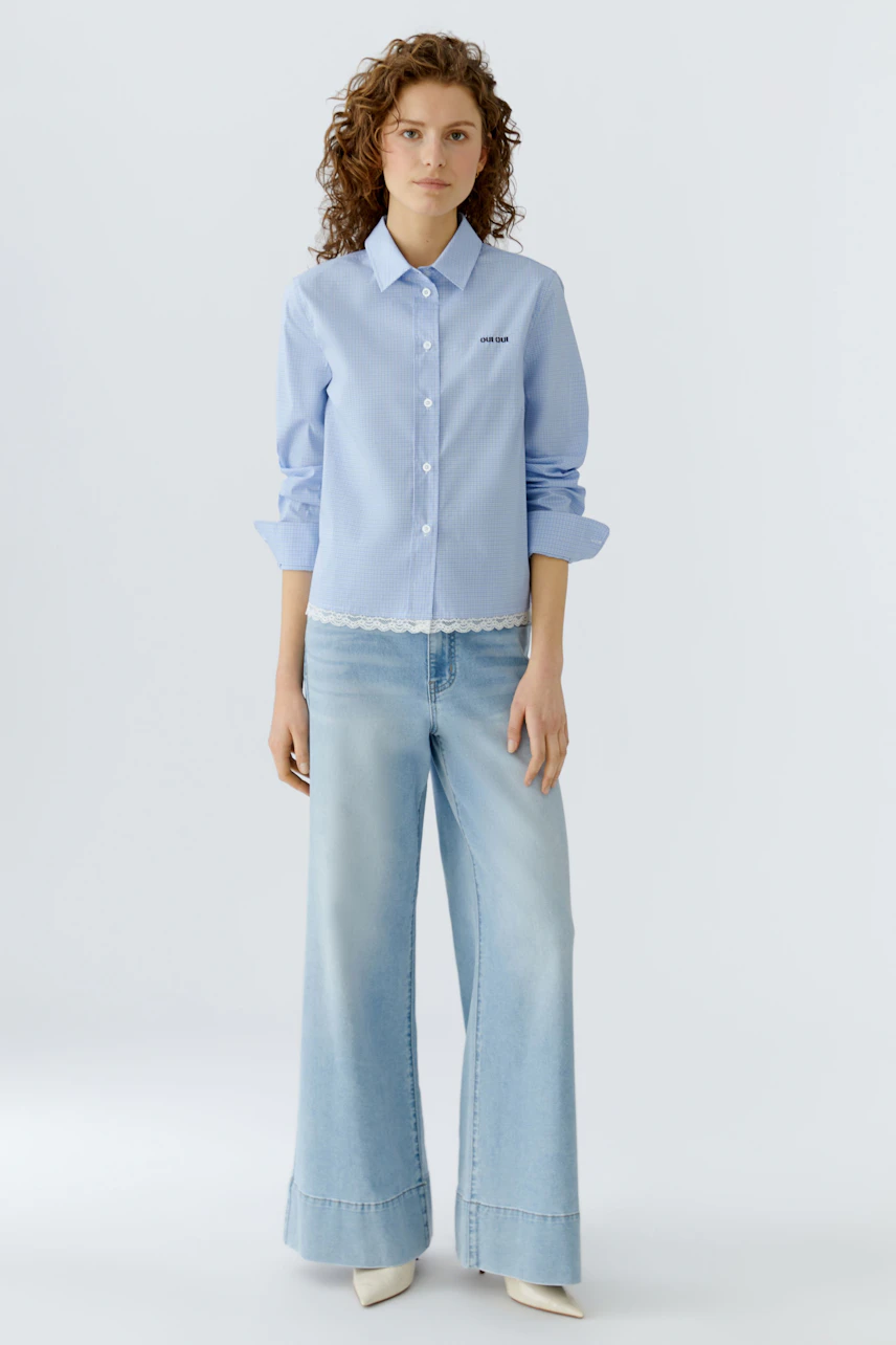 Light blue shirt blouse: Woman in a stylish shirt with lace trim, paired with wide-leg jeans.