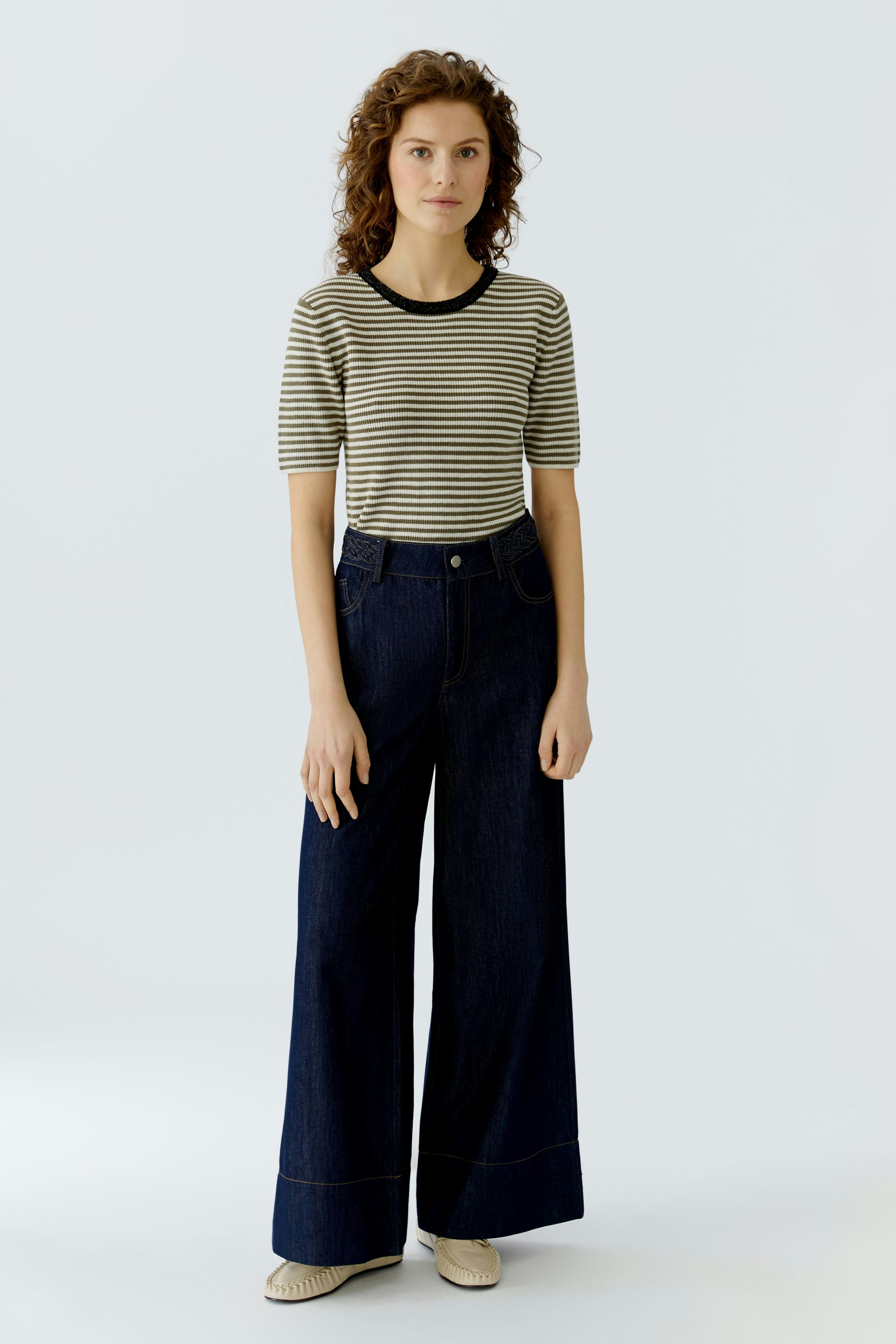 Casual women's pullover: A woman in a striped pullover with a round neckline and wide-leg jeans.