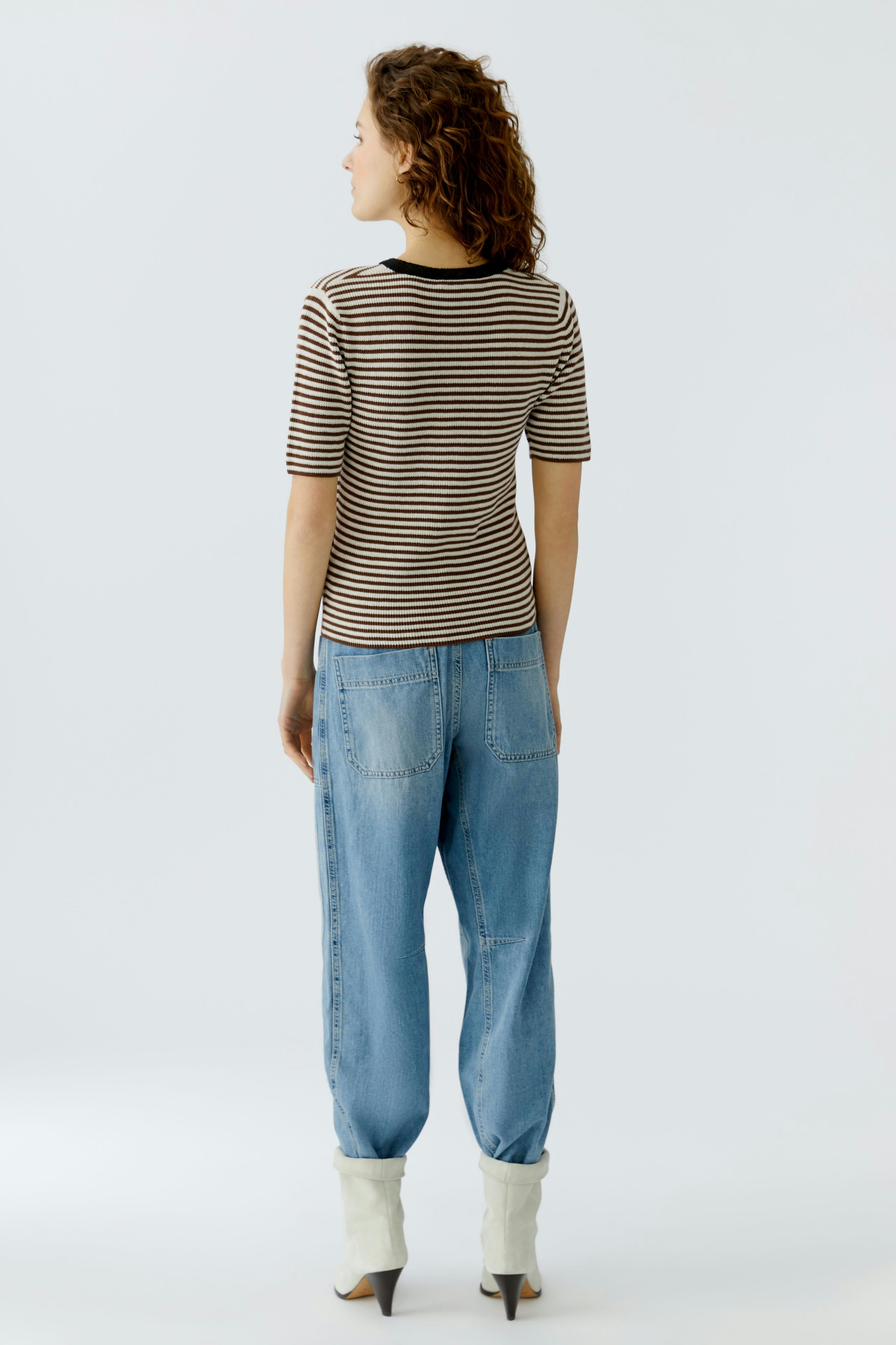 Casual women's pullover: A woman in a striped pullover with short sleeves and relaxed-fit jeans.