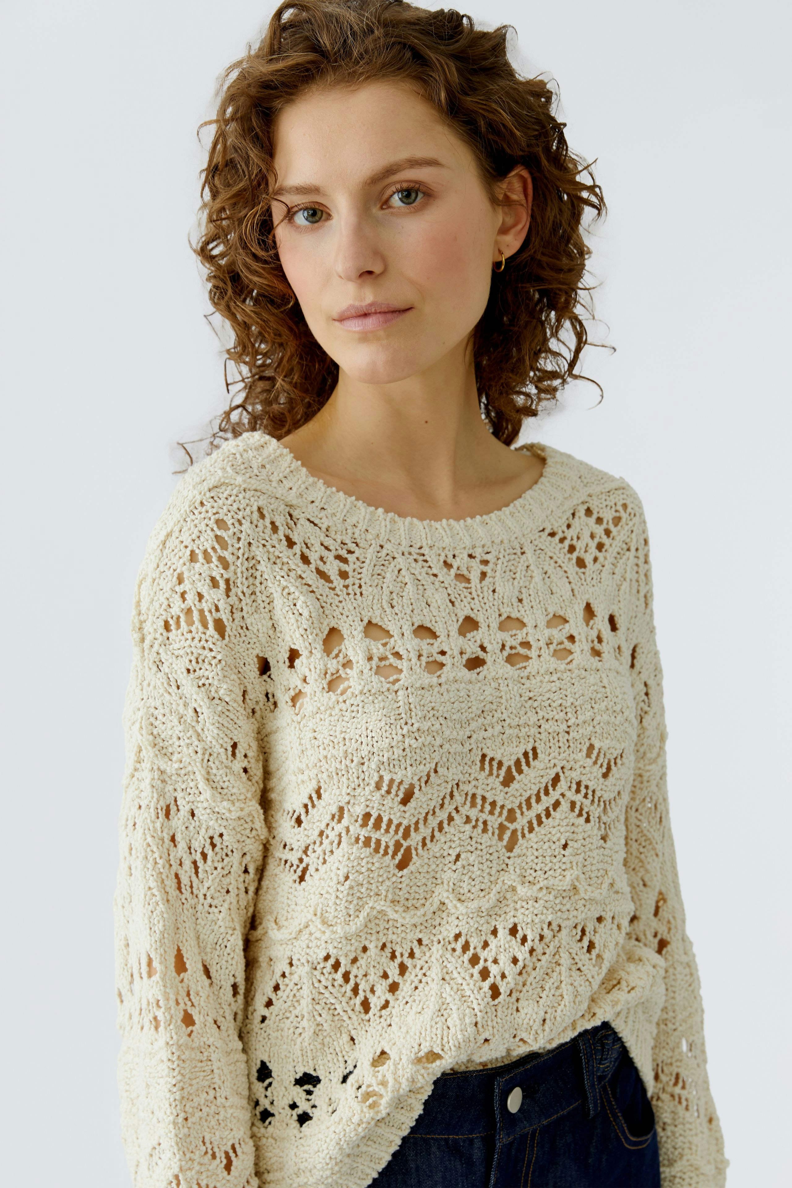 Casual women's pullover: A woman in a cream knitted pullover with an open pattern, exuding a relaxed vibe.