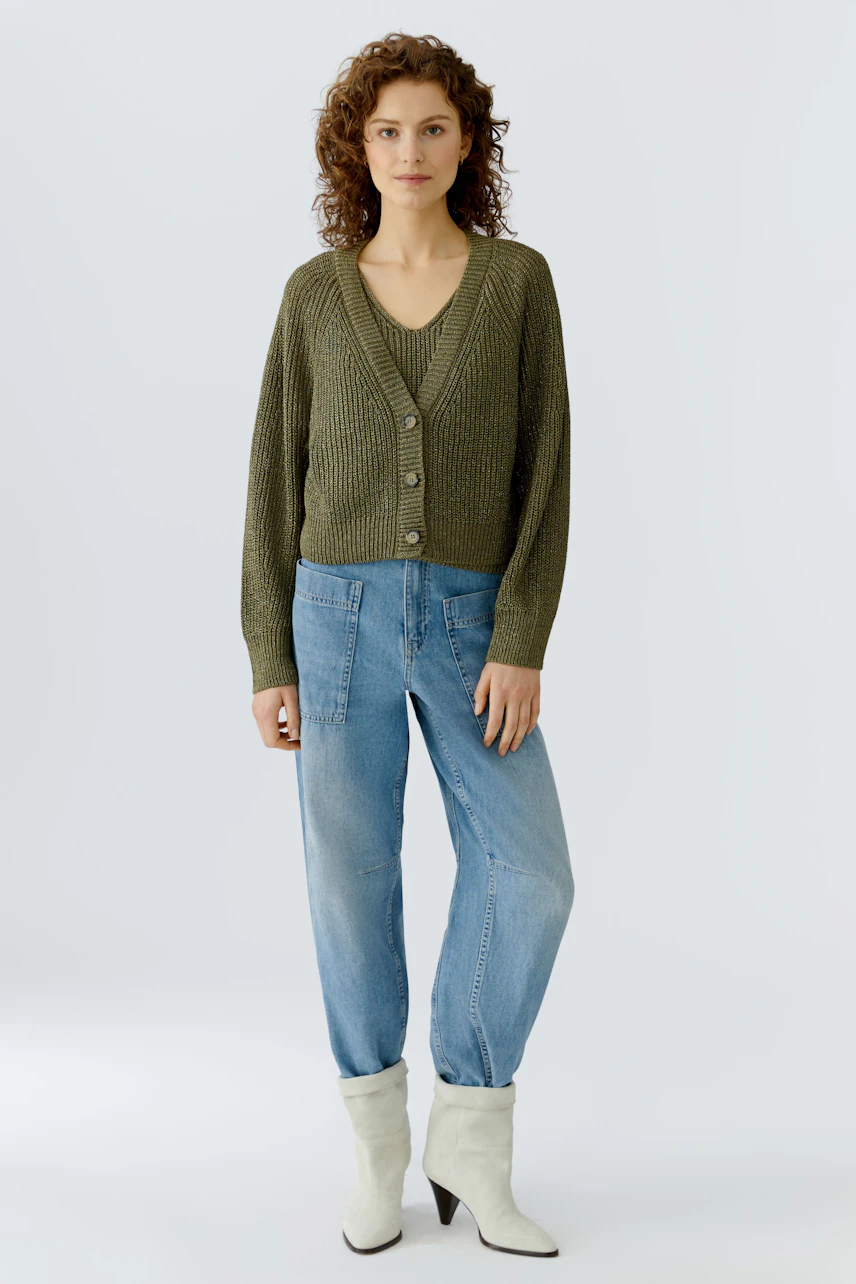 Damen-Strickjacke in Olivgrün: Frau trägt die lockere Jacke über einem Top und kombiniert sie mit Jeans.